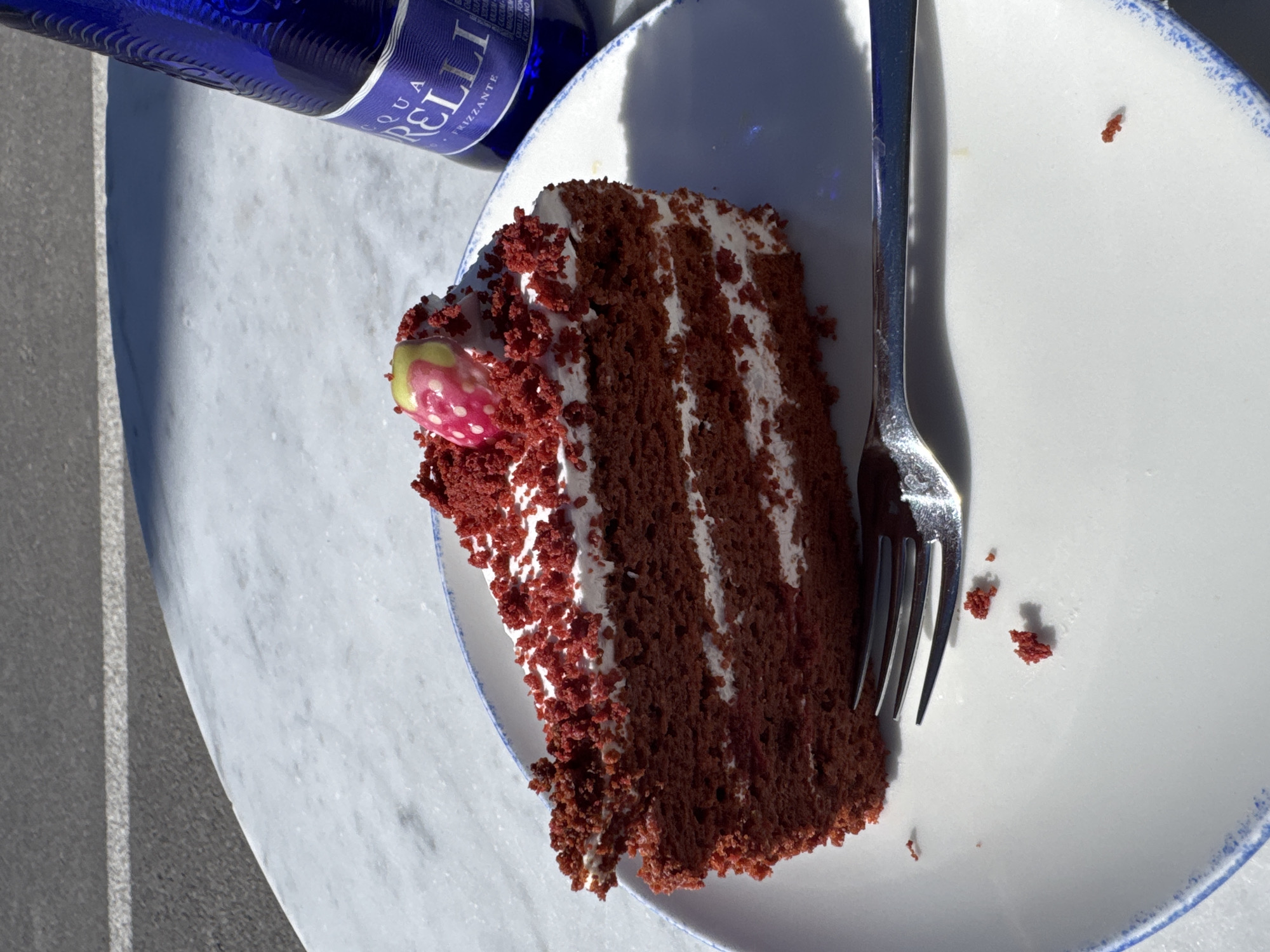 Red velvet cake enjoyed at outdoor table in Andratx
