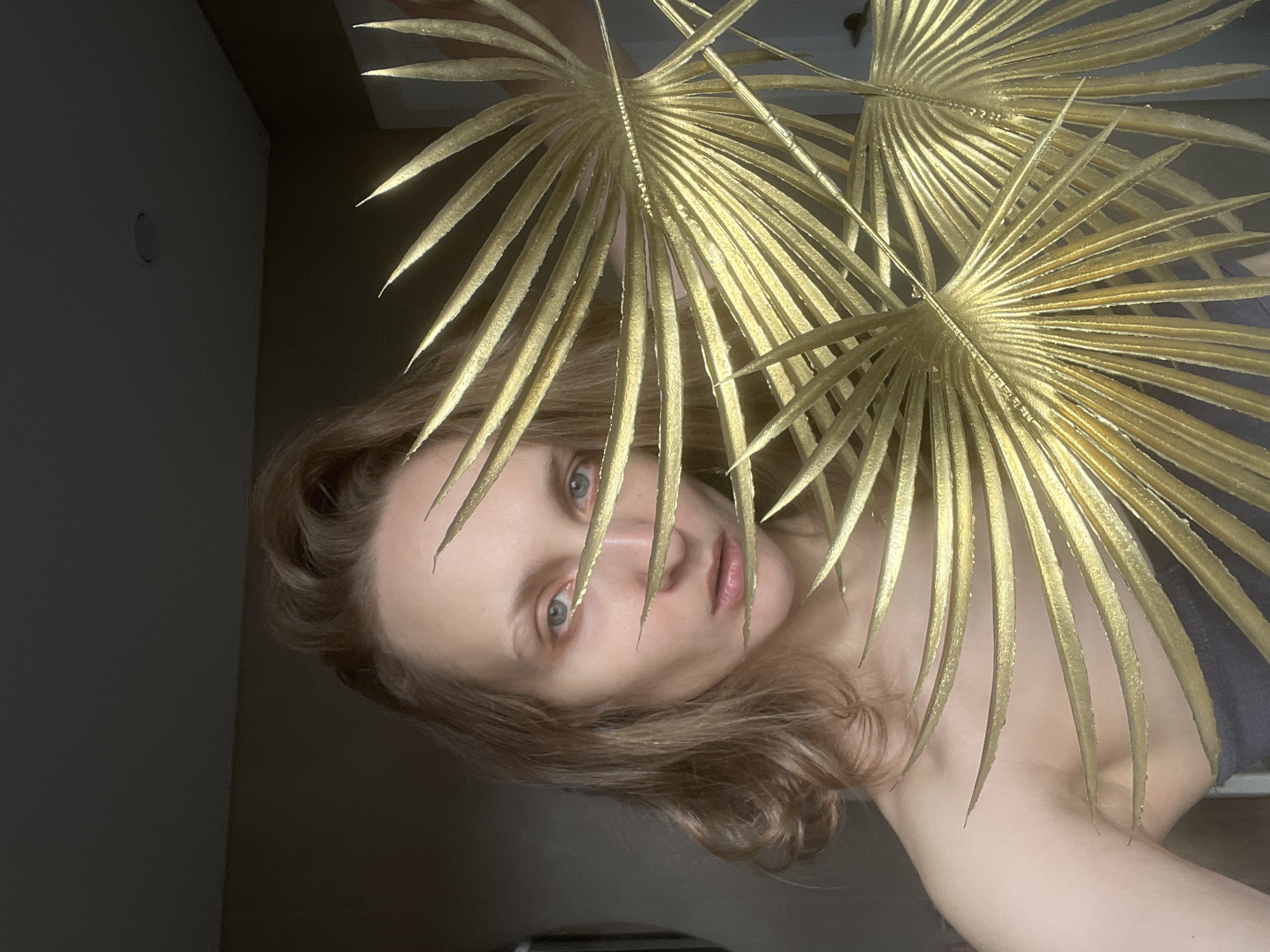 Woman poses behind gilded palm fronds in Podshivalovo portrait