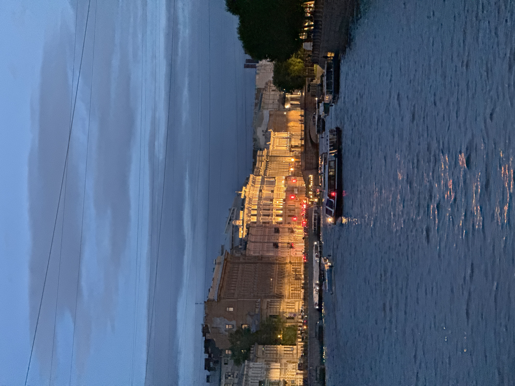 Pink-clad tourist documents evening Saint Petersburg river walk, landmarks