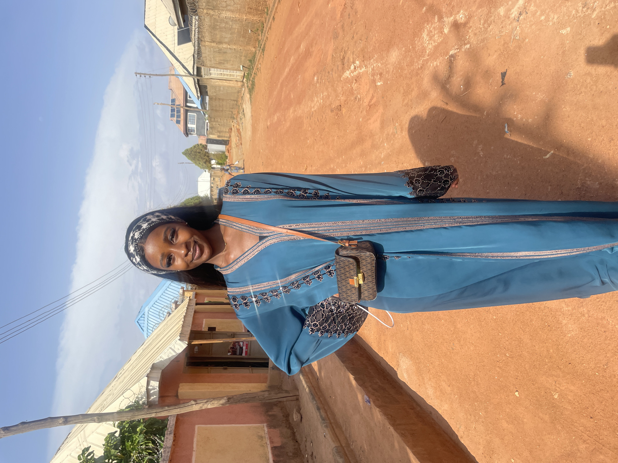 Woman uses smartphone on dirt road in Rido, Nigeria