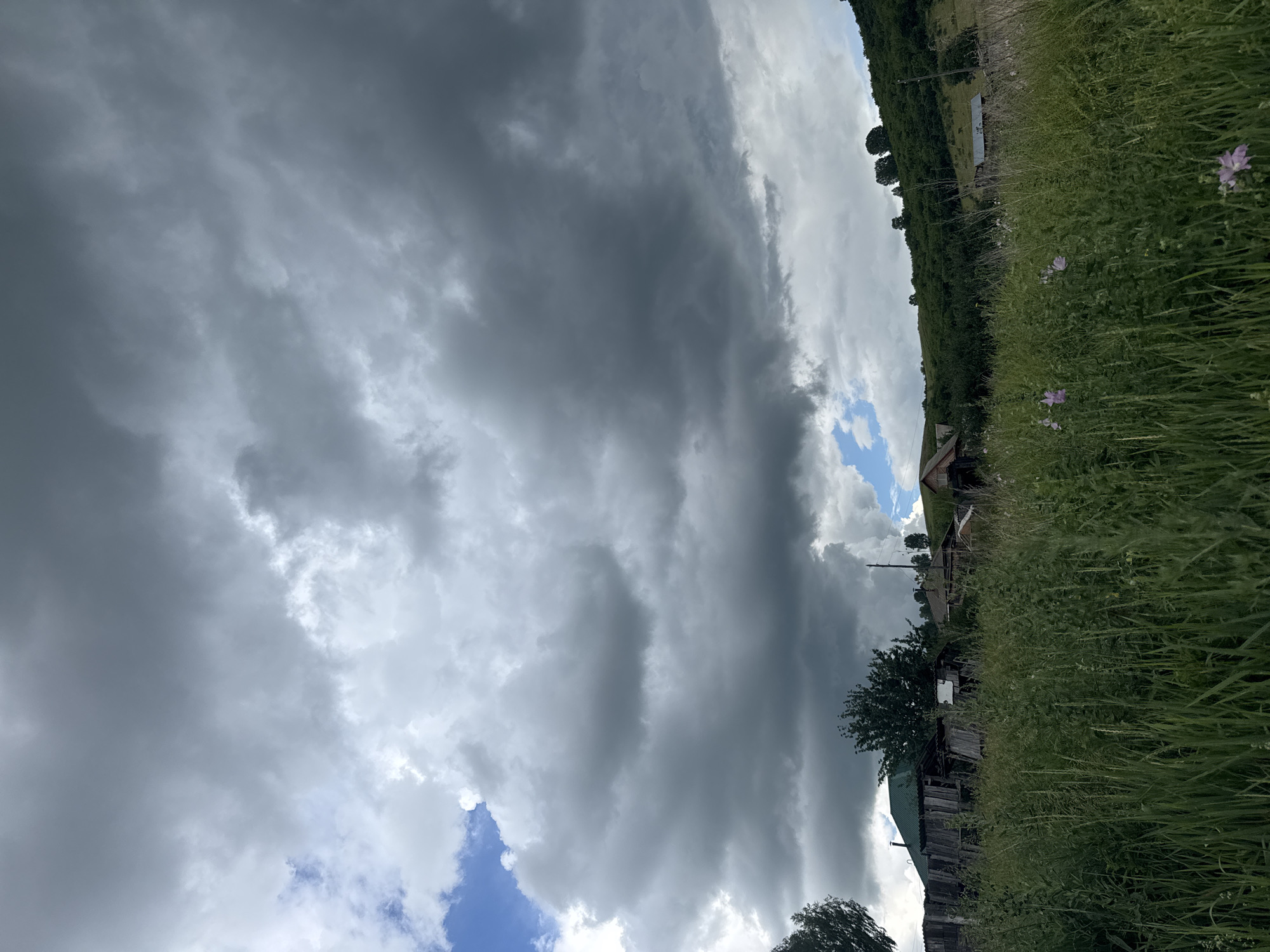 Storm clouds gather over rural Soloneshnoye fields and hills