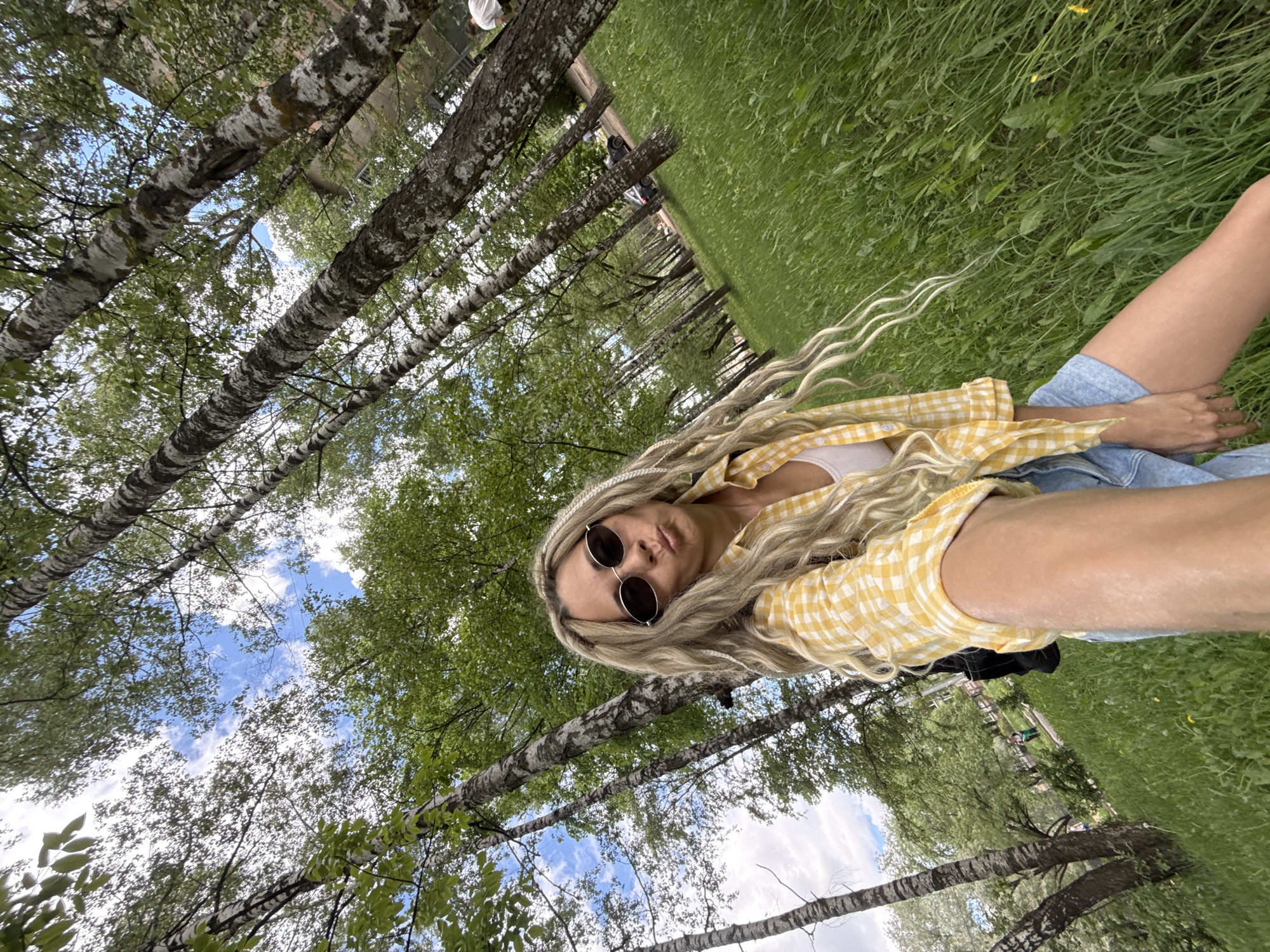 Woman rests in park amid birch trees in Шебунино