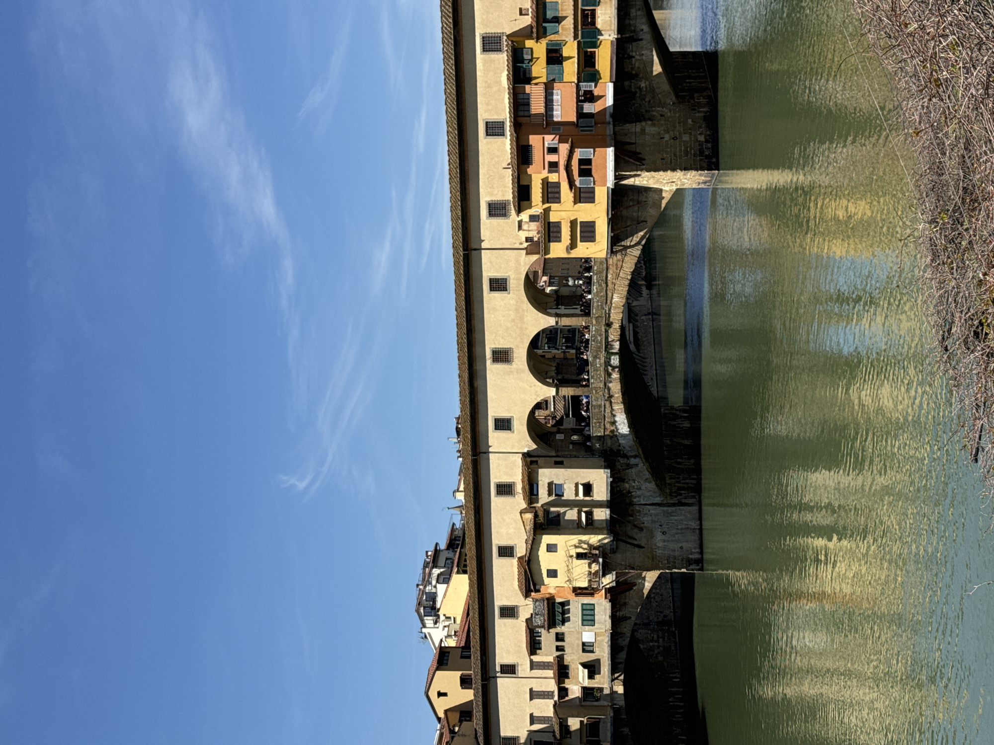 Tourist photographs historic Ponte Vecchio bridge in Florence