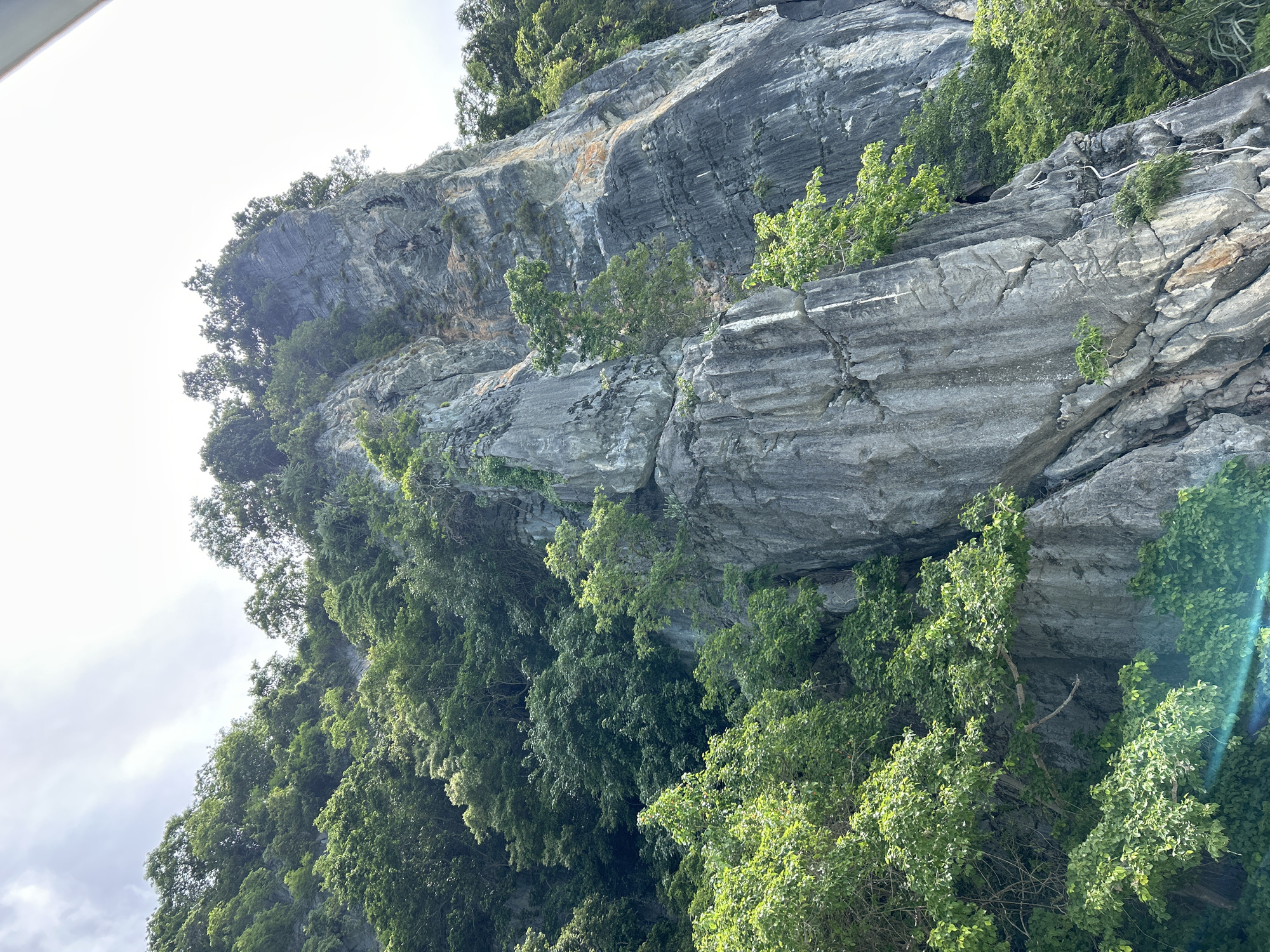 Tour boats and beach crowds at Ko Phi Phi's karst coastline