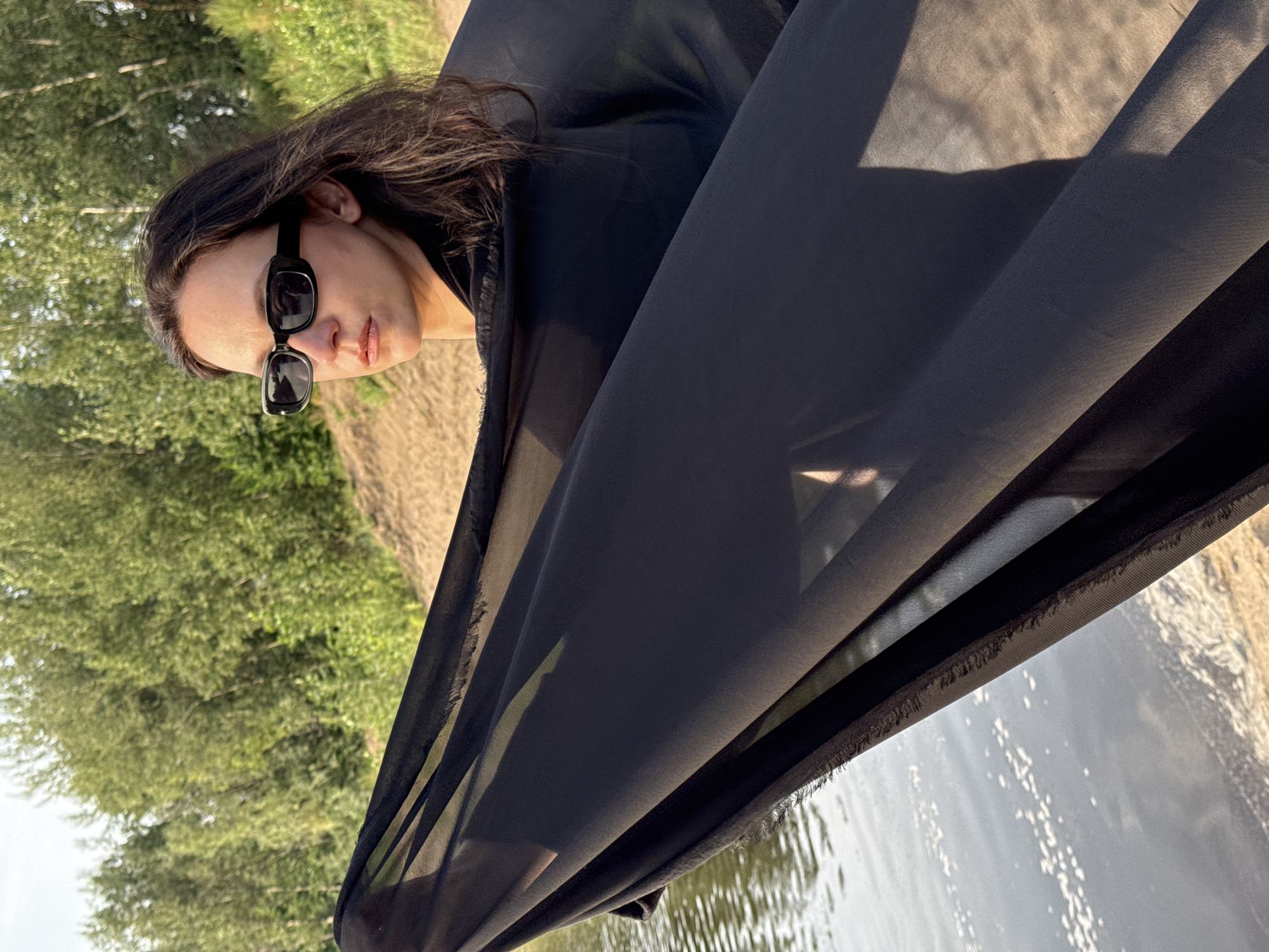 Black fabric, water's edge, midday sun in rural Russia