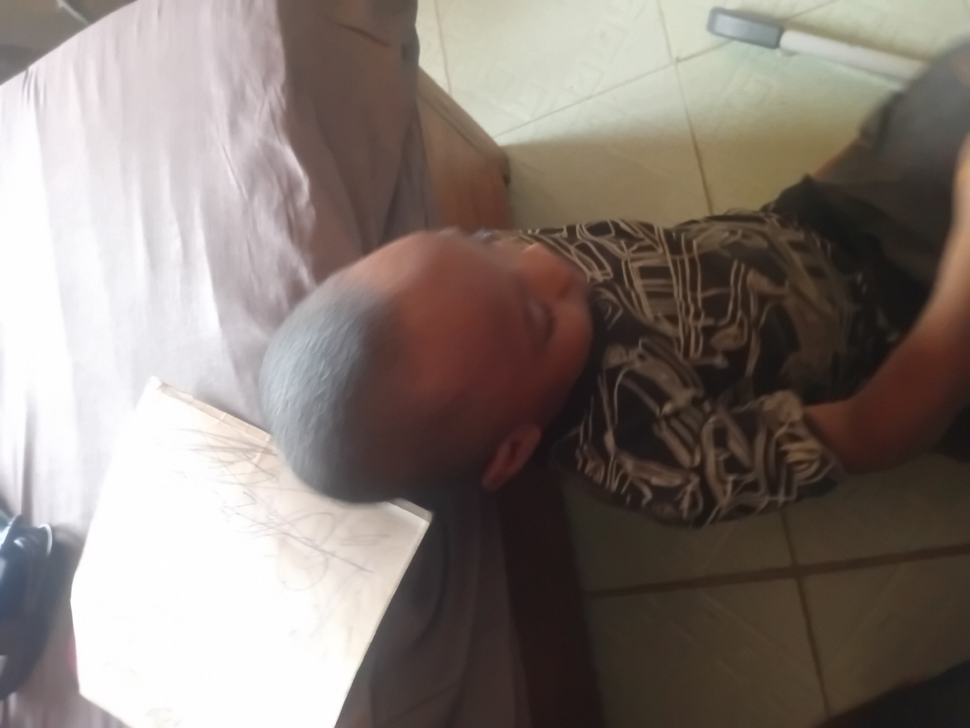 Child resting on floor against furniture edge