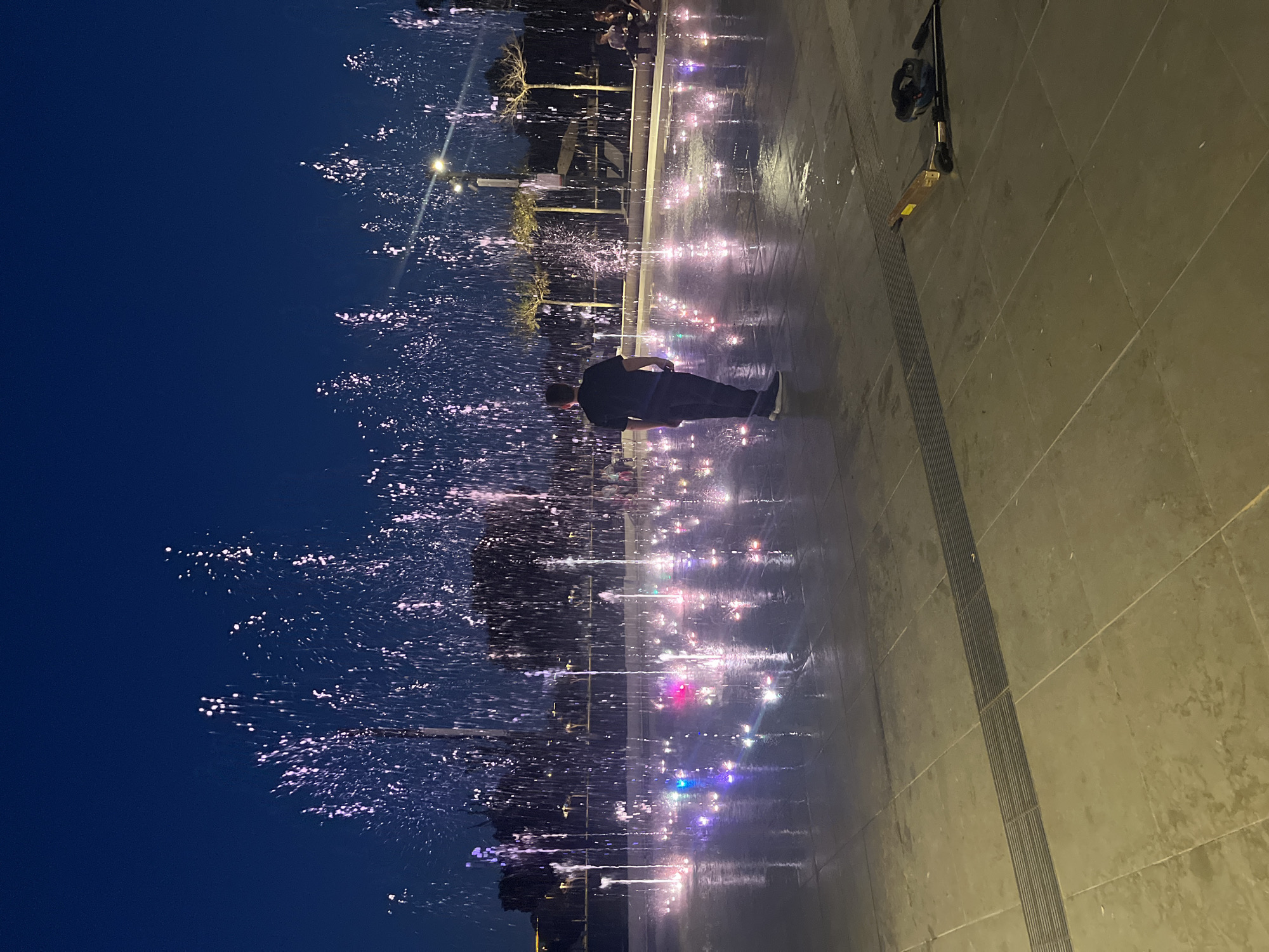 Person interacts with illuminated fountain in Ramat Gan