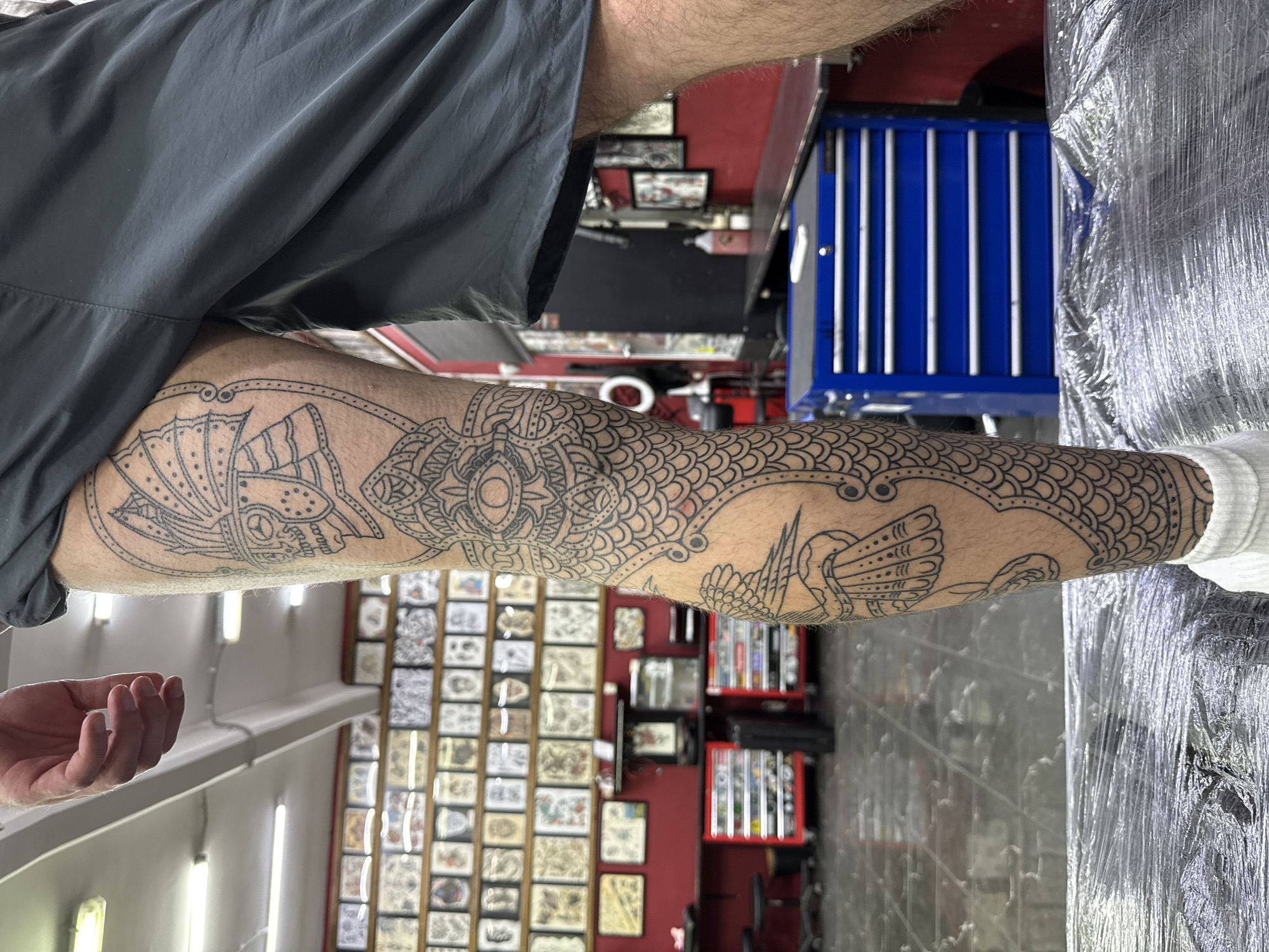 Person displays intricate leg tattoos featuring Orthodox church in Moscow