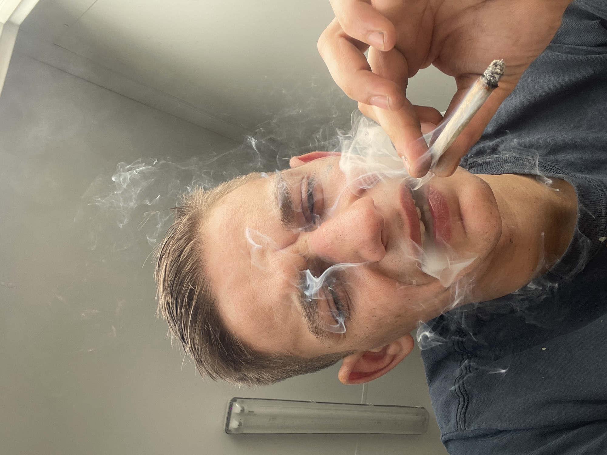 Man documents smoking session in industrial building with safety gear