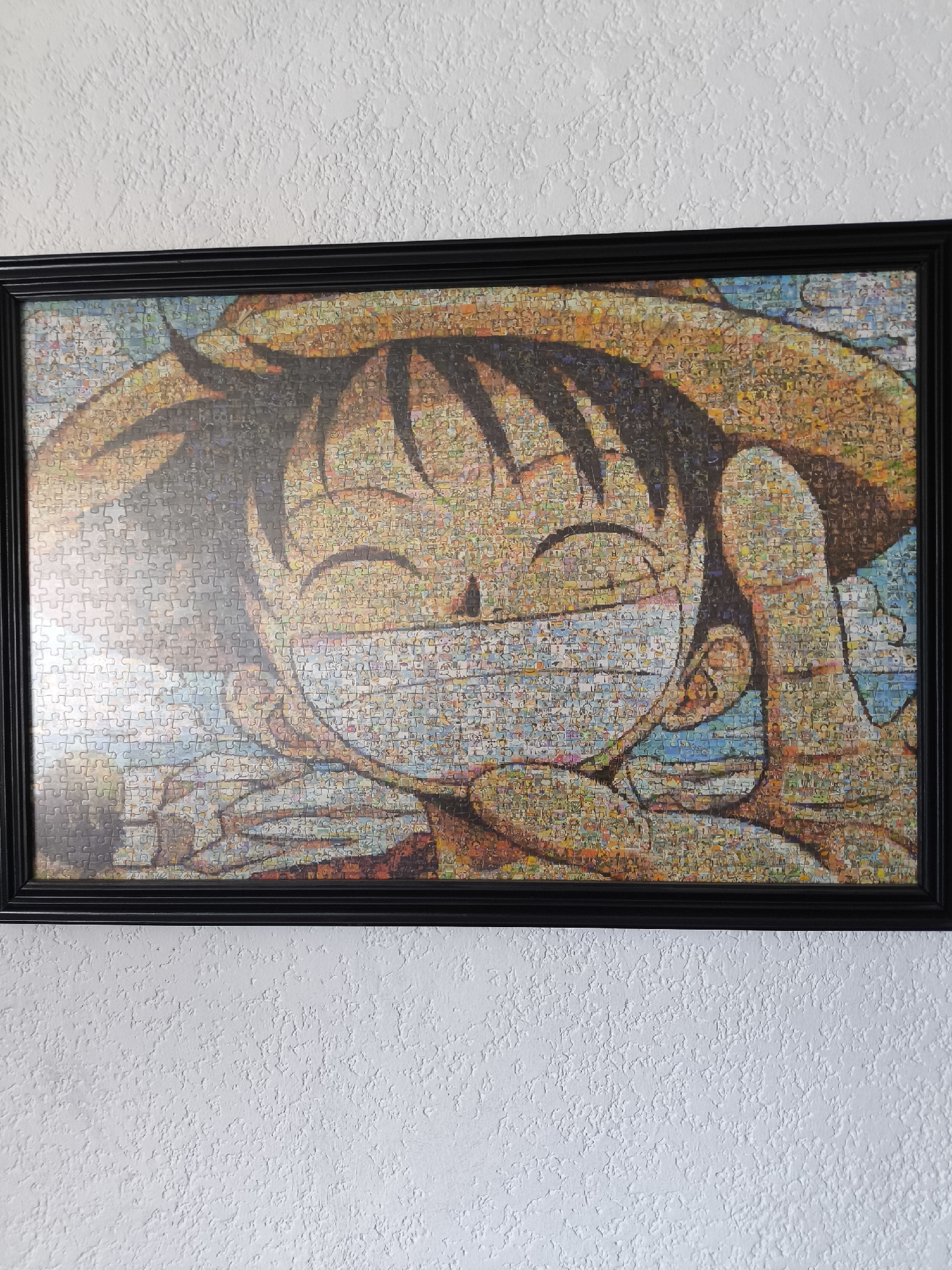 Anime and hat artwork displayed on wall in Puebla