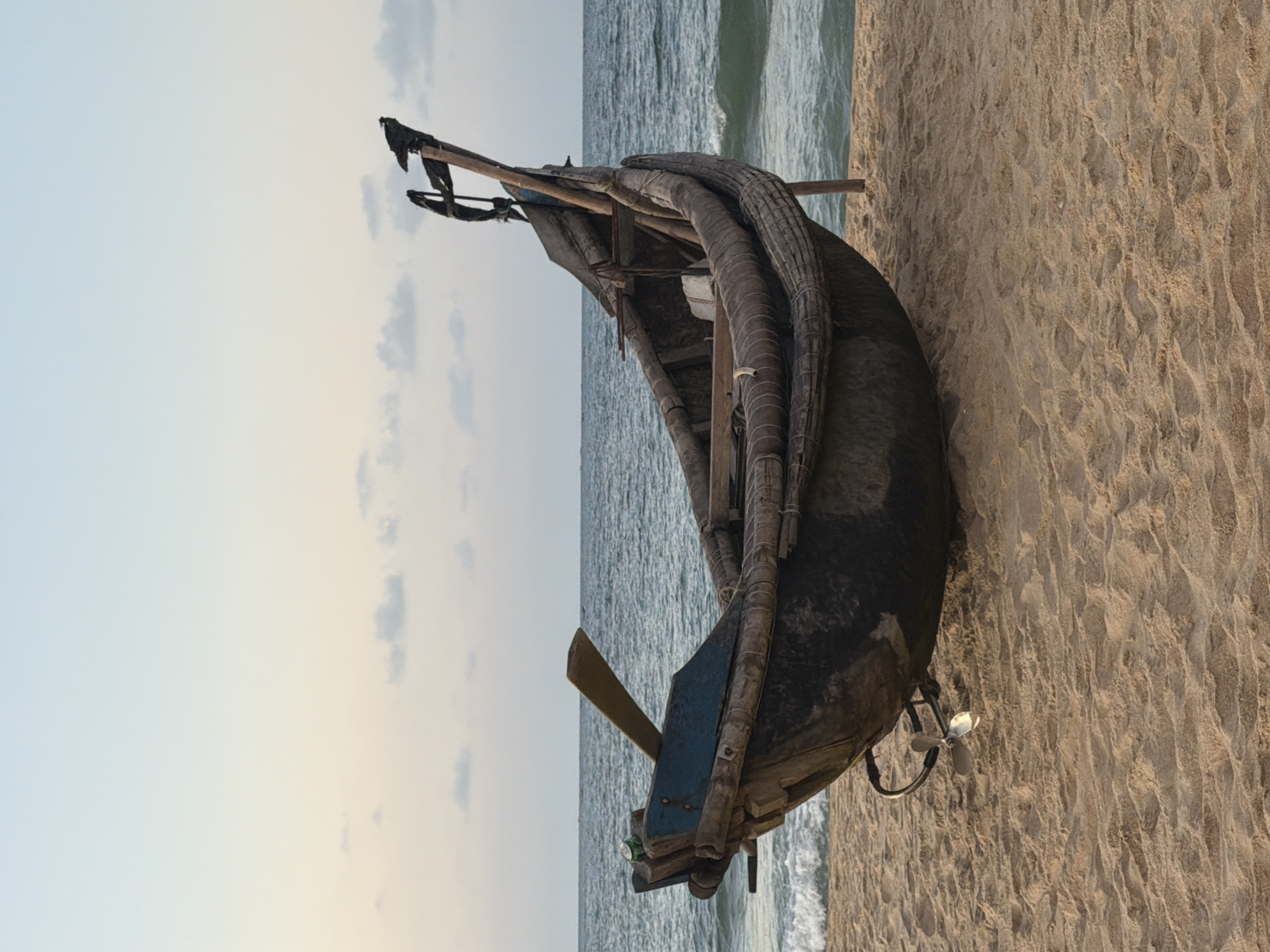 Beach scene captures fishing boat and child at play
