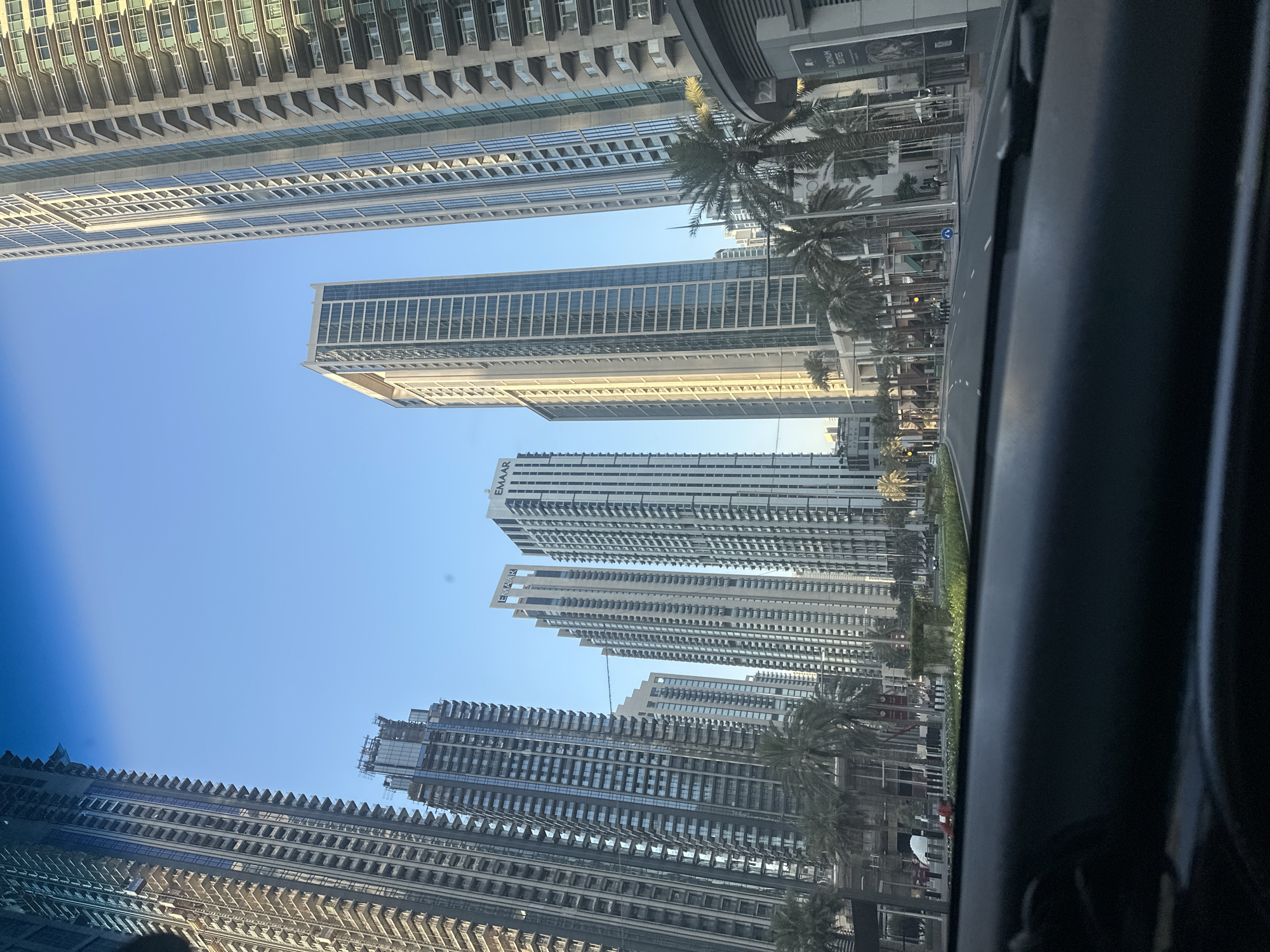 Street-level drive past Dubai's high-rise skyline