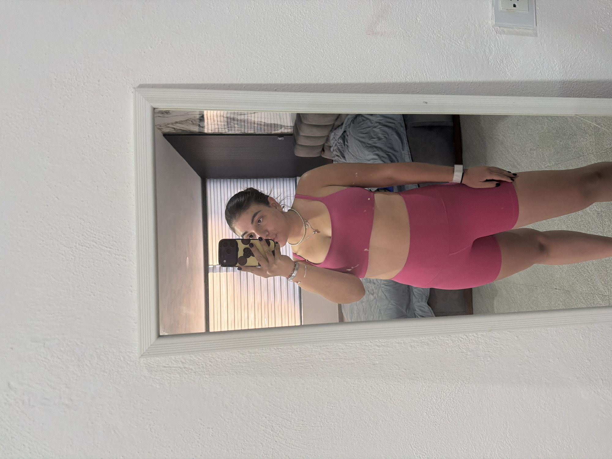 Woman takes mirror selfies in pink workout attire, Puebla