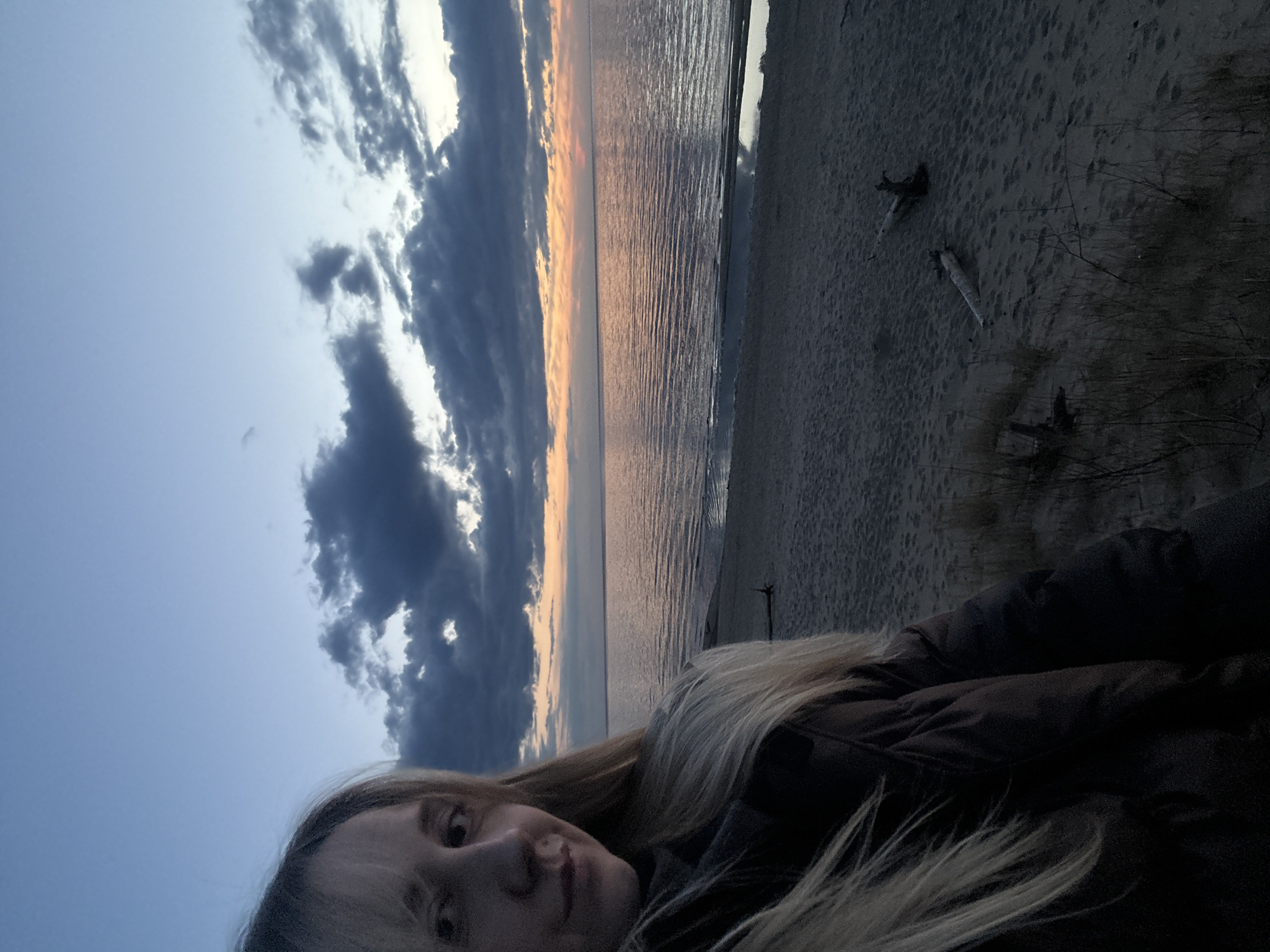 Woman takes beach selfie at sunset in Riga