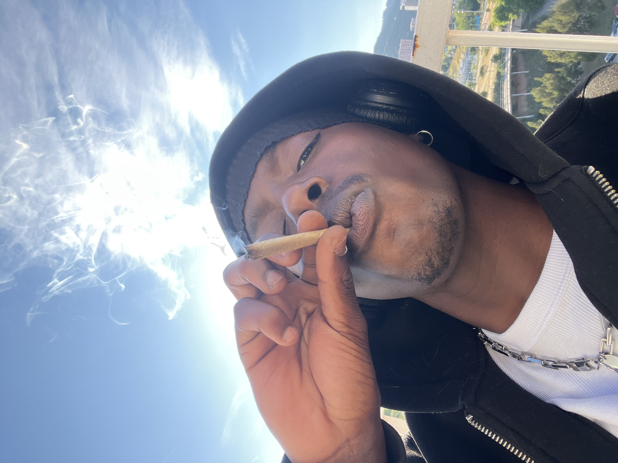 Man smoking on Barcelona balcony overlooks cityscape
