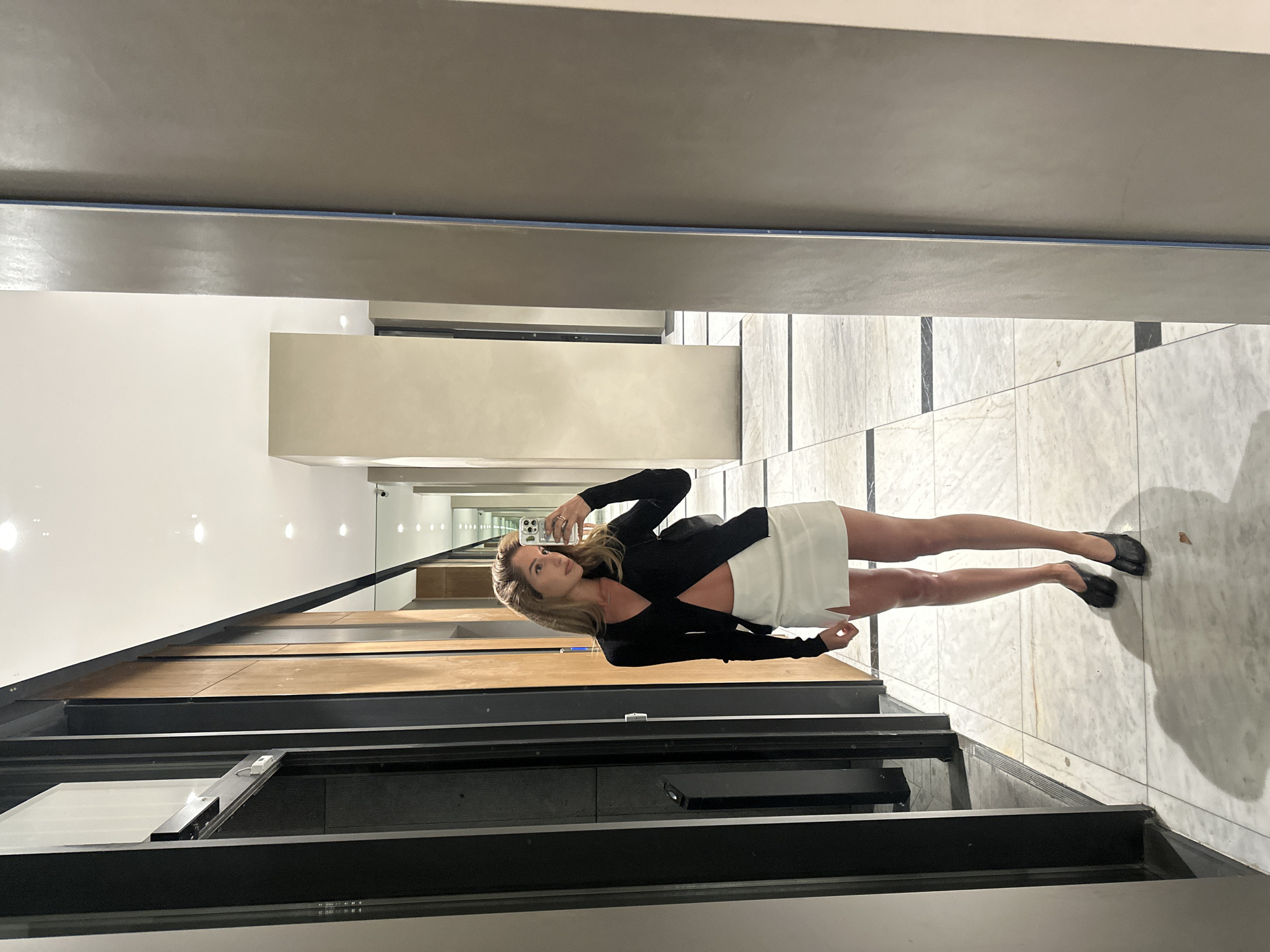 Mirror selfie in a bright Tbilisi hallway, two angles