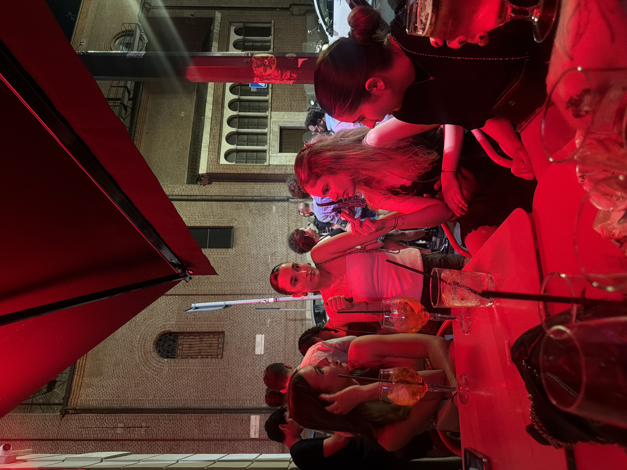 Evening drinks at a red-lit outdoor bar in Milan