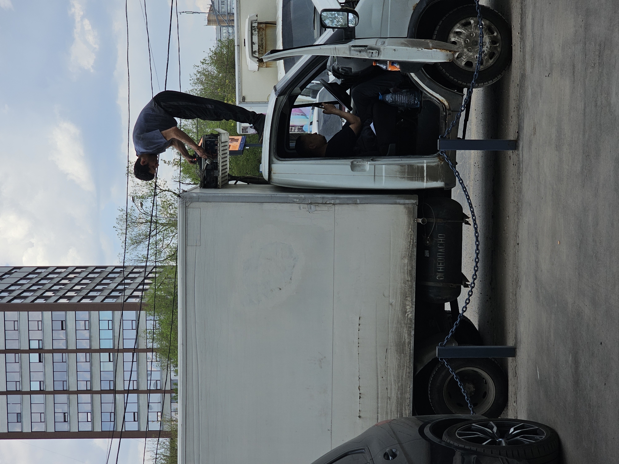 Two men service commercial truck in Moscow