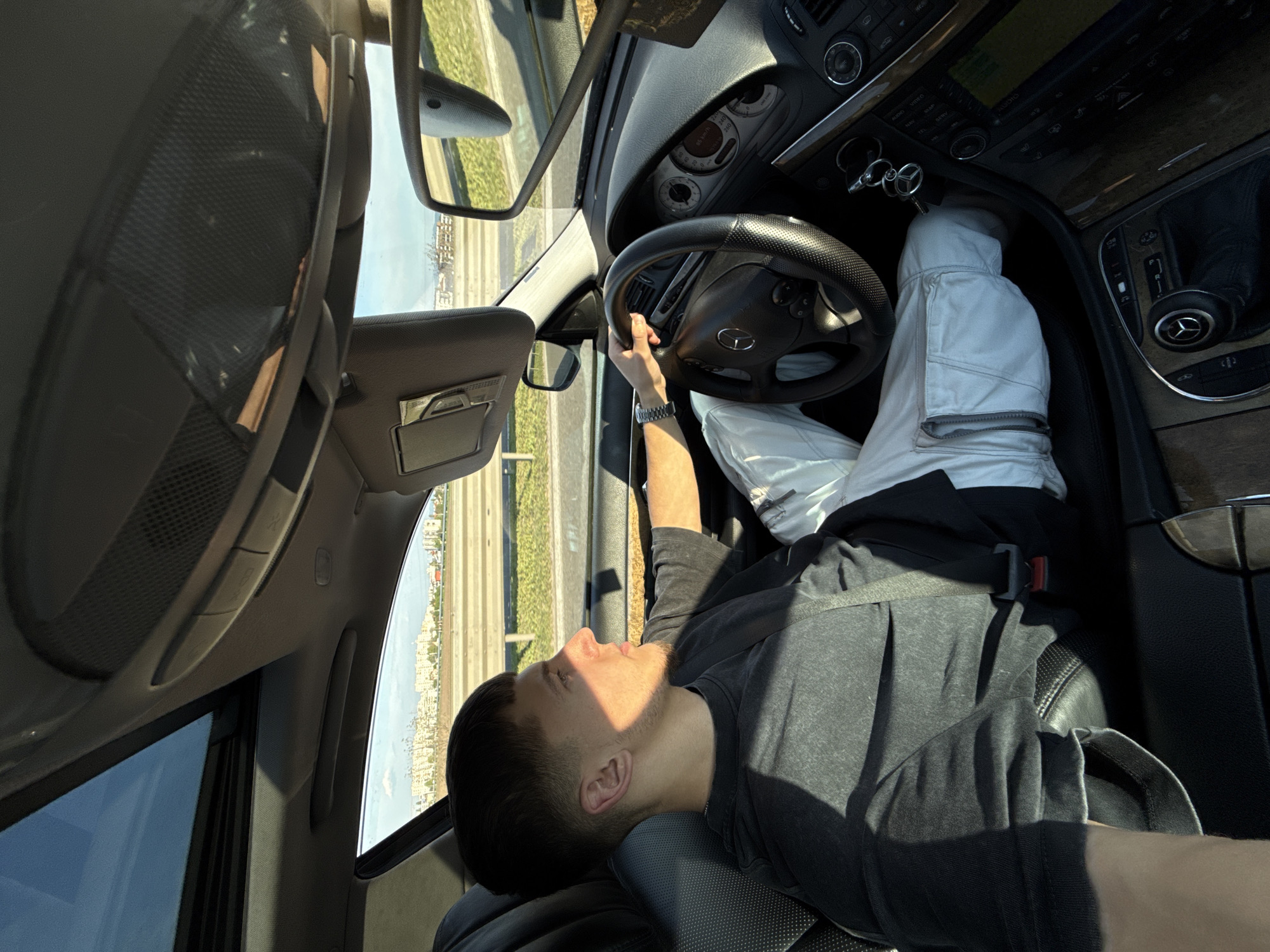Driver reclines with feet on dashboard in Sofia Mercedes