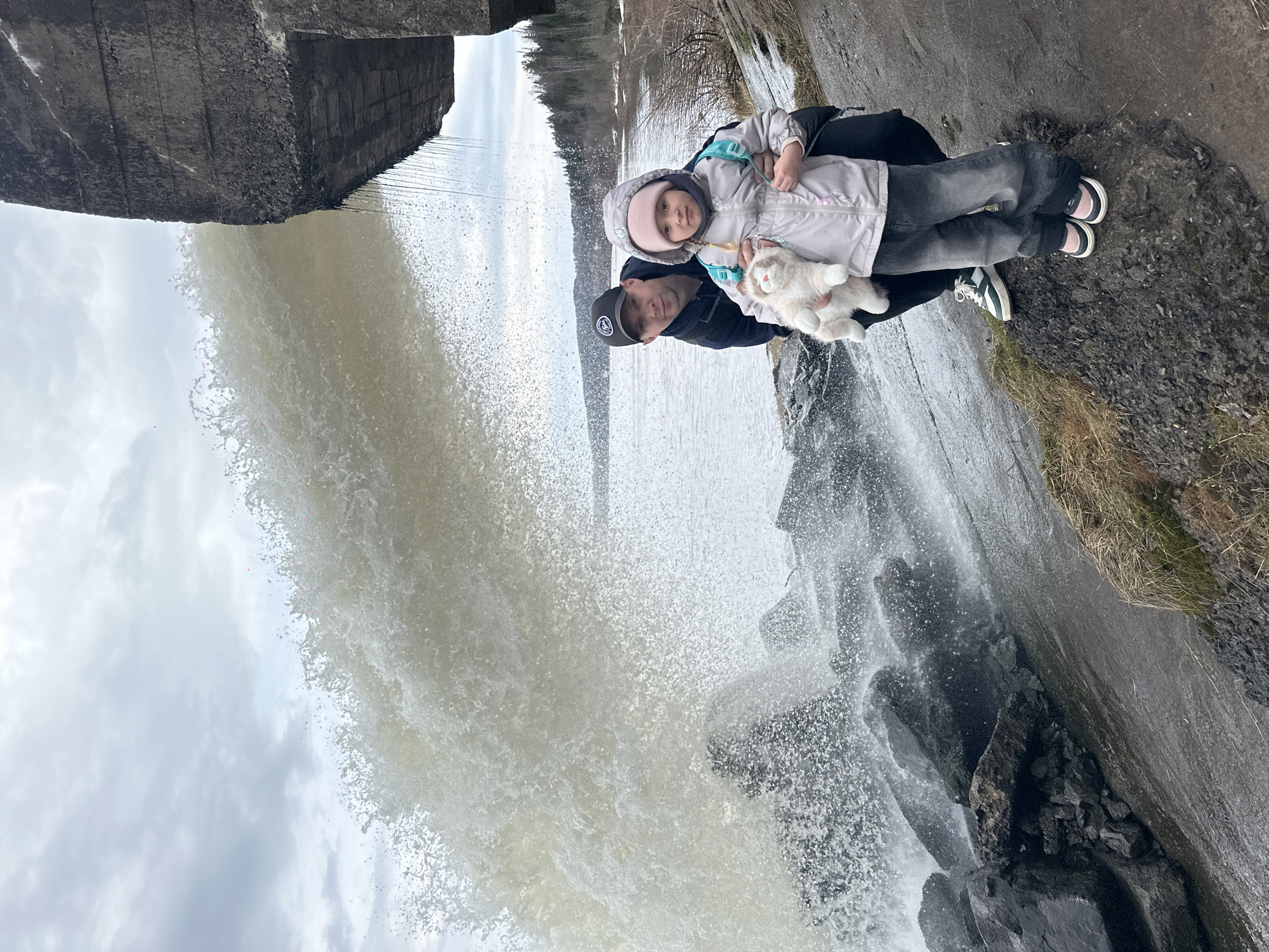 Family visits waterfall dam in Noviy, Russia