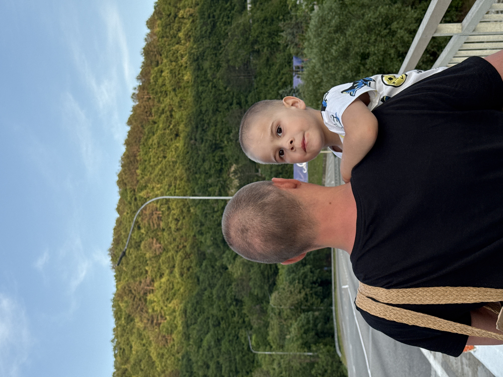 Father carries child on bridge in Nebug, Russia