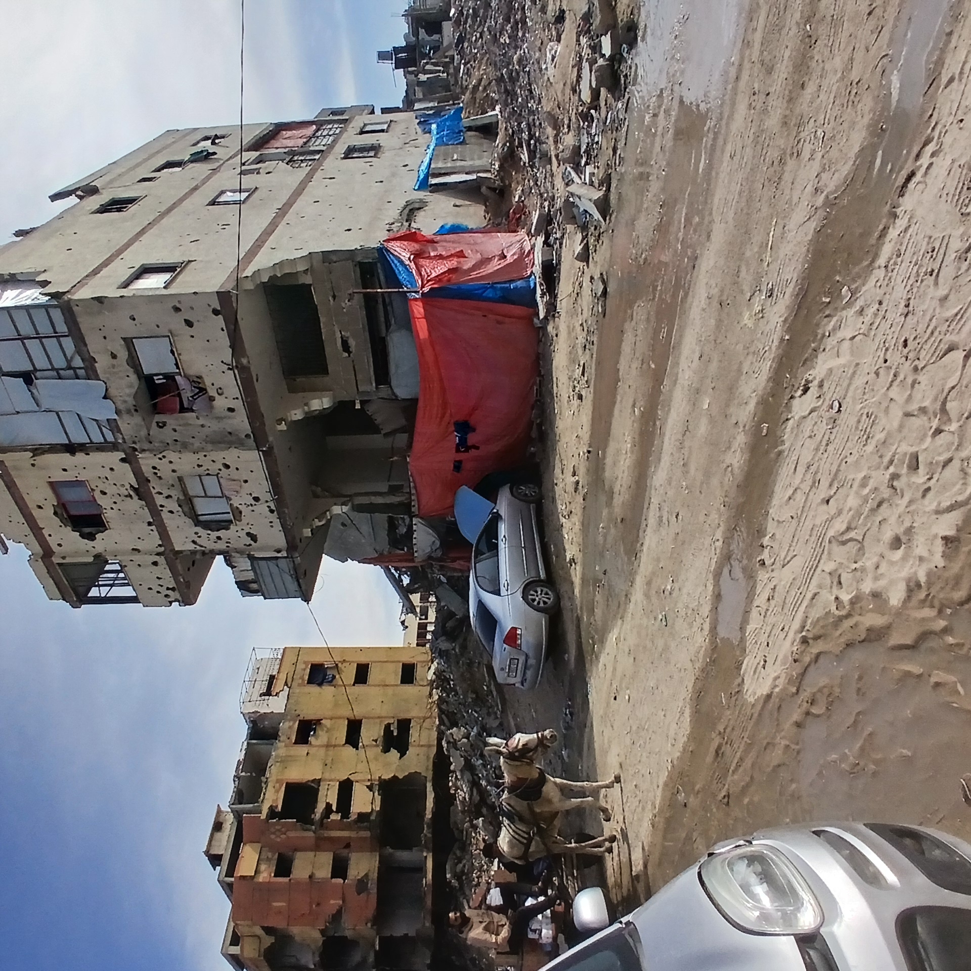 Gaza residents collect water amid widespread building destruction