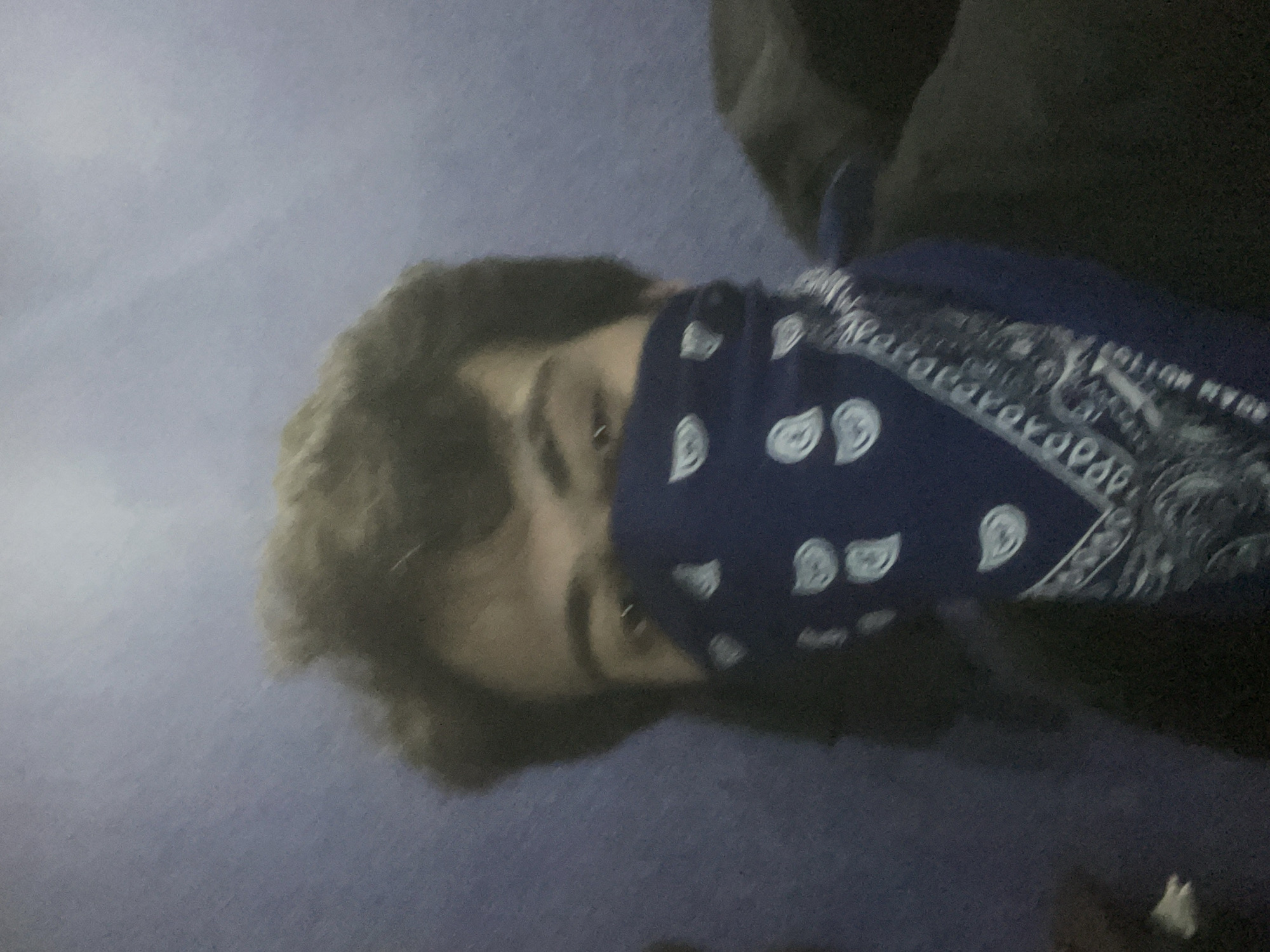 Young man documents bandana selfie session in Tbilisi room