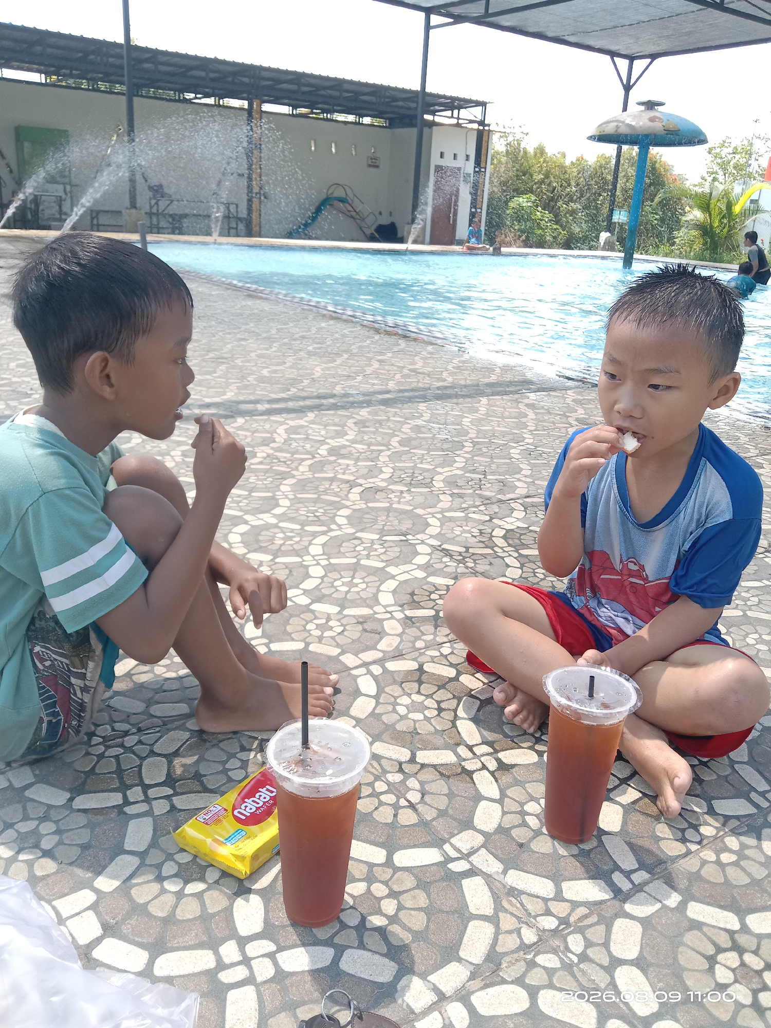 Kids and adults at a swimming pool in Blimbing, Indonesia