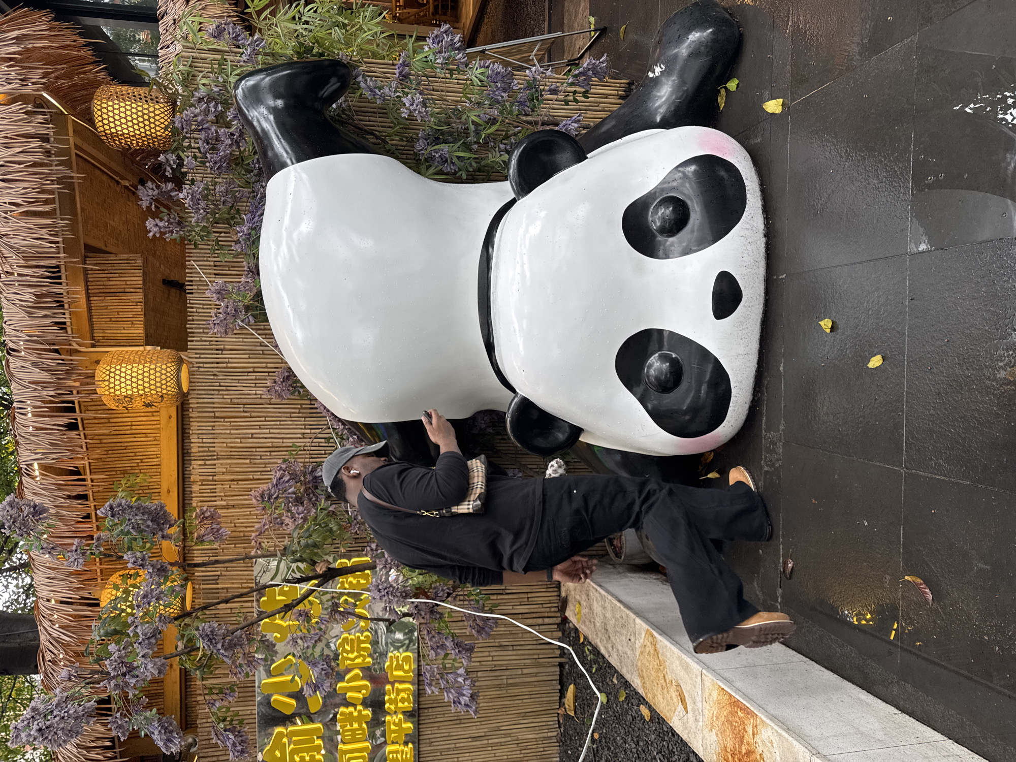 Women photographing teacups, walking on wet sidewalk in Jinjiang