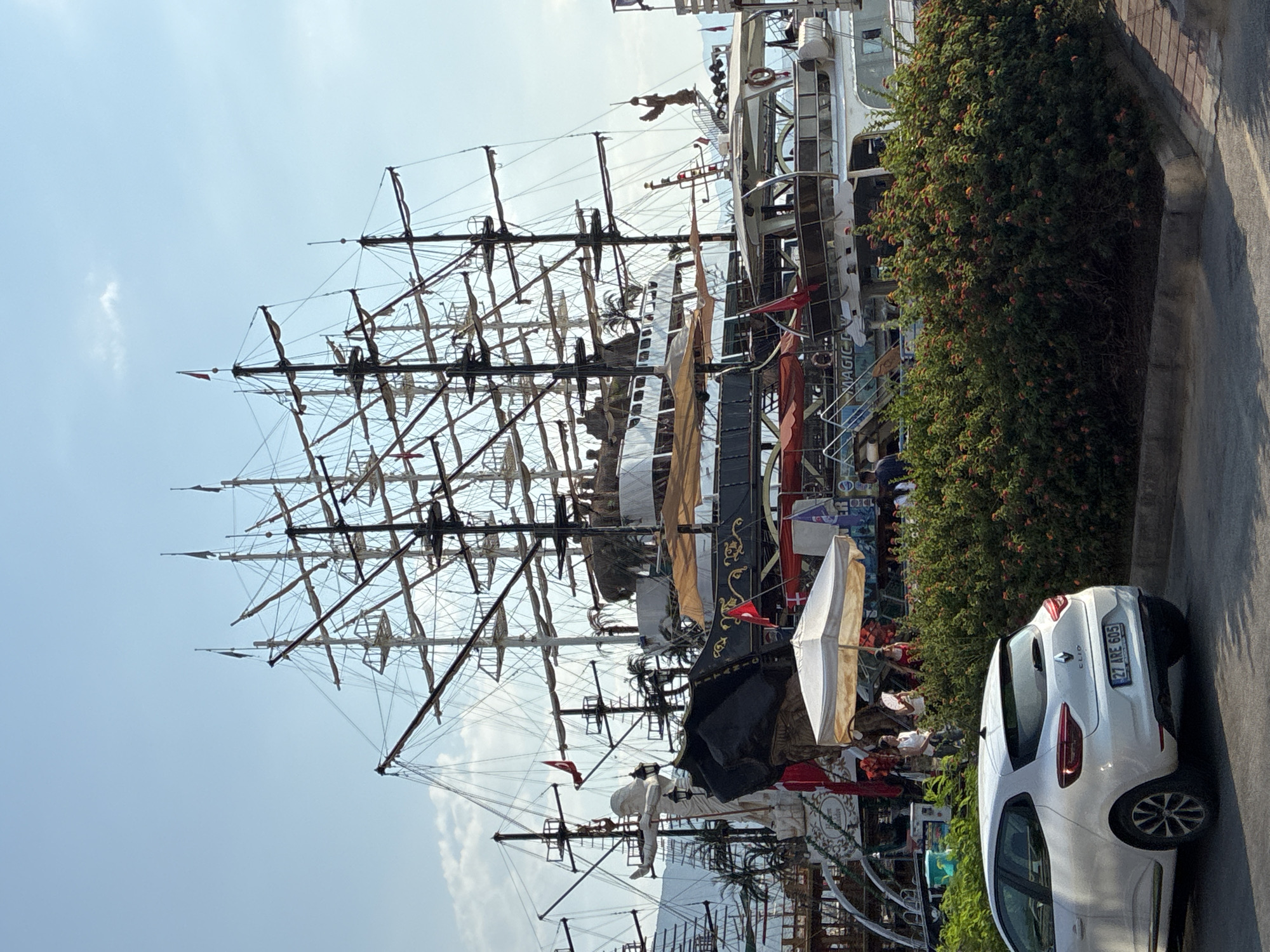 Alanya harbor: sailing ships docked along a palm-lined promenade