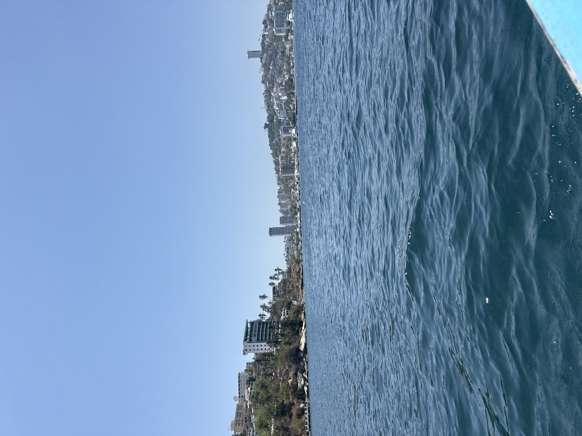 Boat view captures Acapulco coastline and blue waters