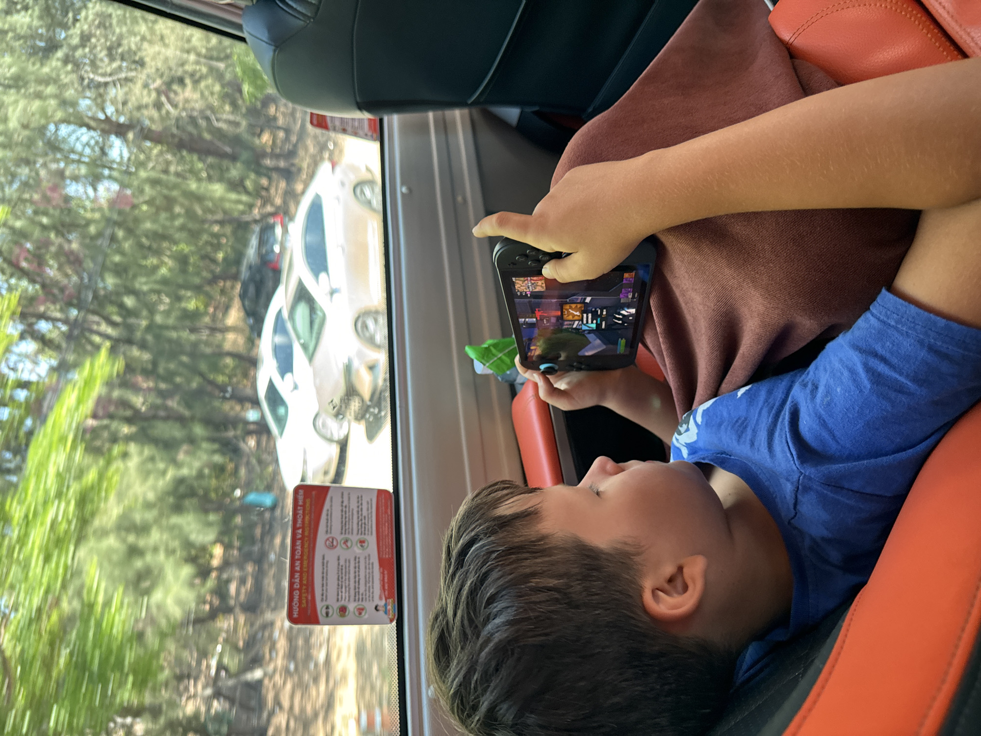 Child plays mobile game during vehicle journey in Vietnam