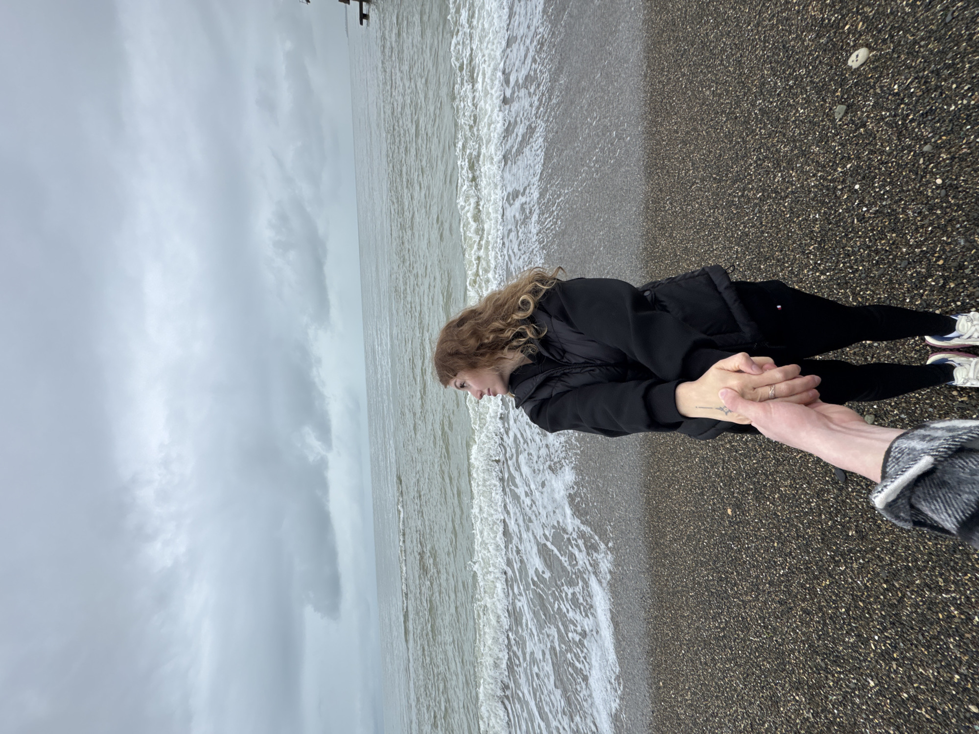 Woman spends quiet moment on Abkhazian beach during overcast day