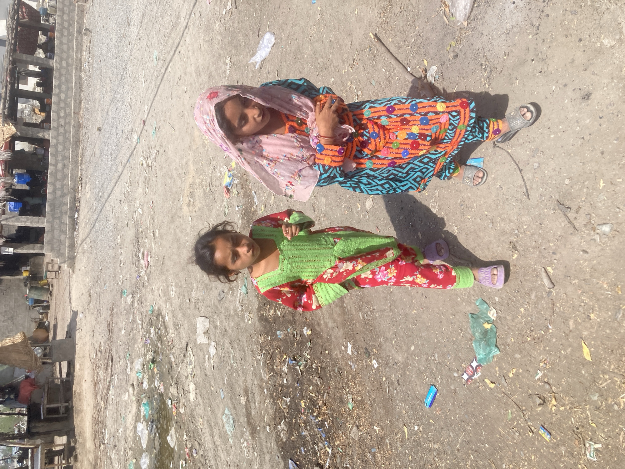 Two girls spotted on dusty ground in Uthal, Pakistan