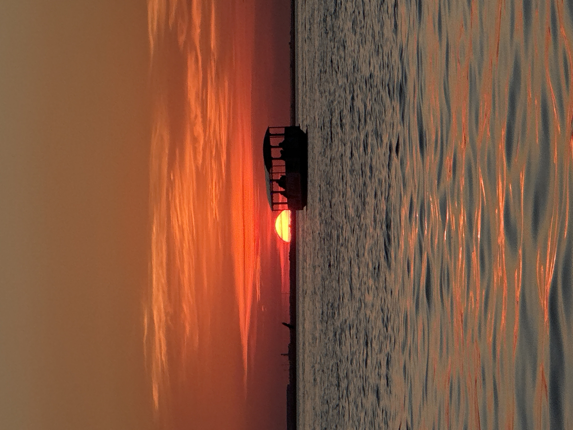 Boat silhouetted against fiery sunset on Kokshetau waters