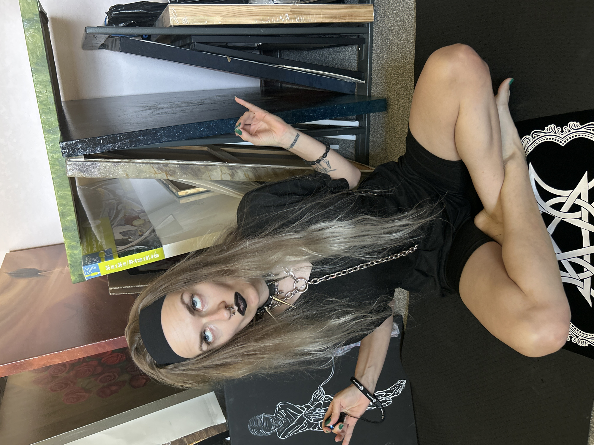 Artist works among artwork stacks in Cape Coral studio