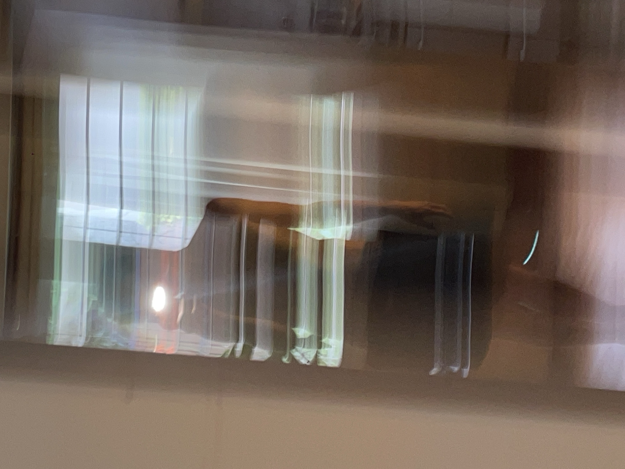 Blurry window view with chair reflection captured in Vicente López