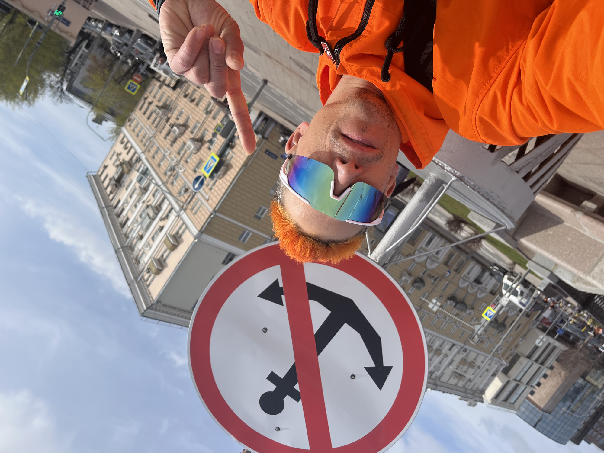 Orange-clad tourist poses by Moscow River no-anchoring sign