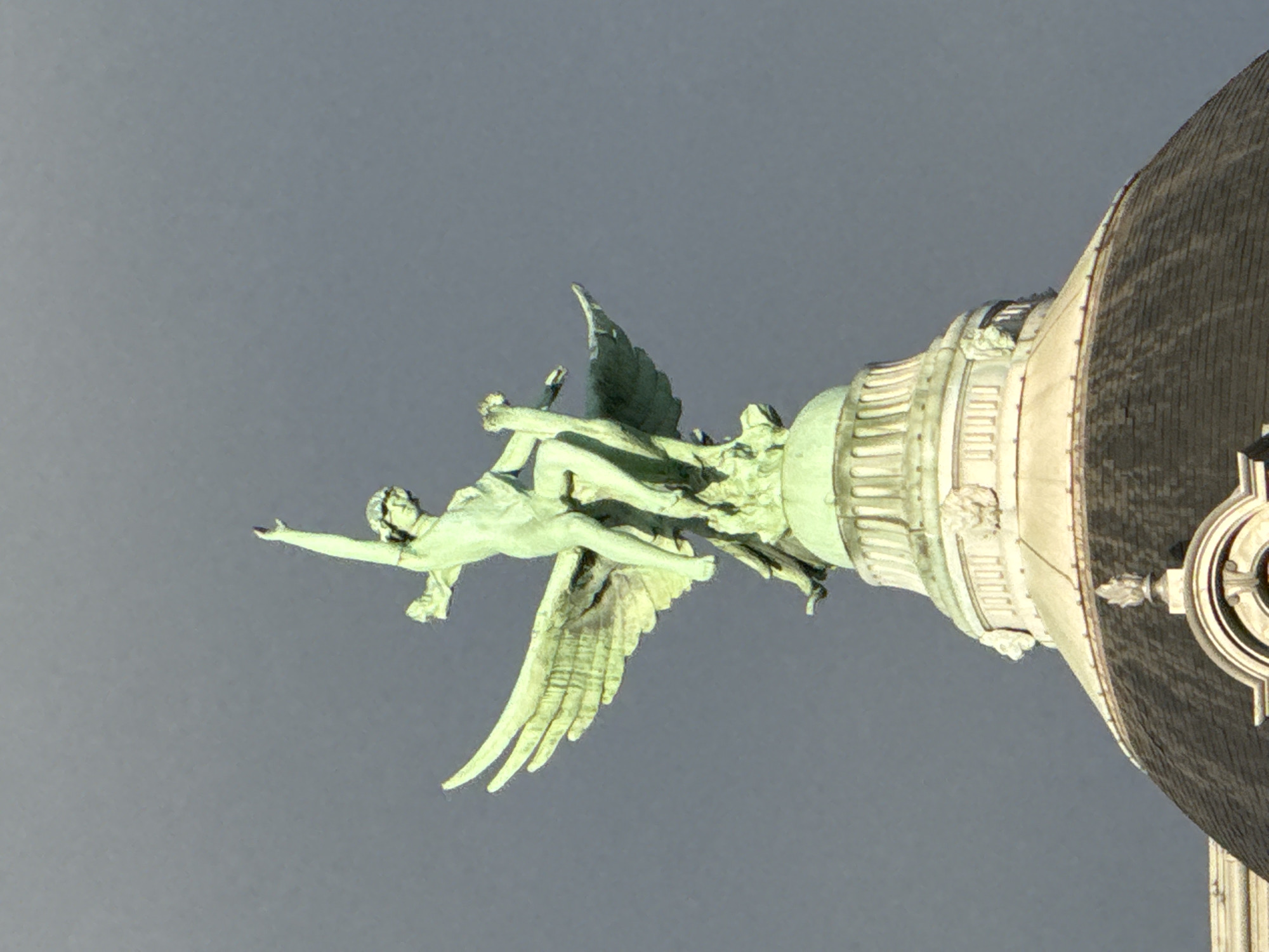 Green angelic statue observed on classical Paris architecture