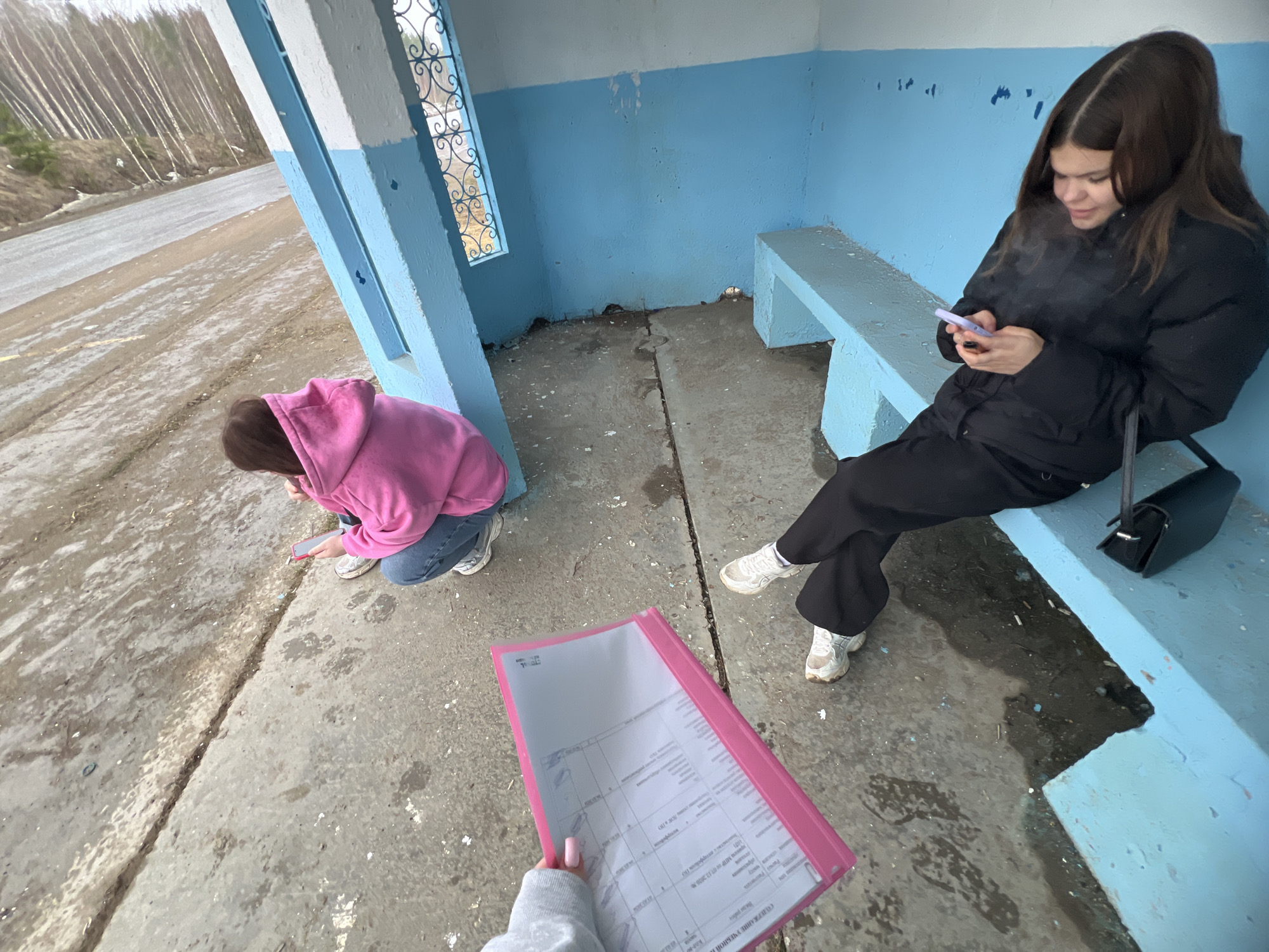 Young women wait at bus stop in Chaikovsky, Russia