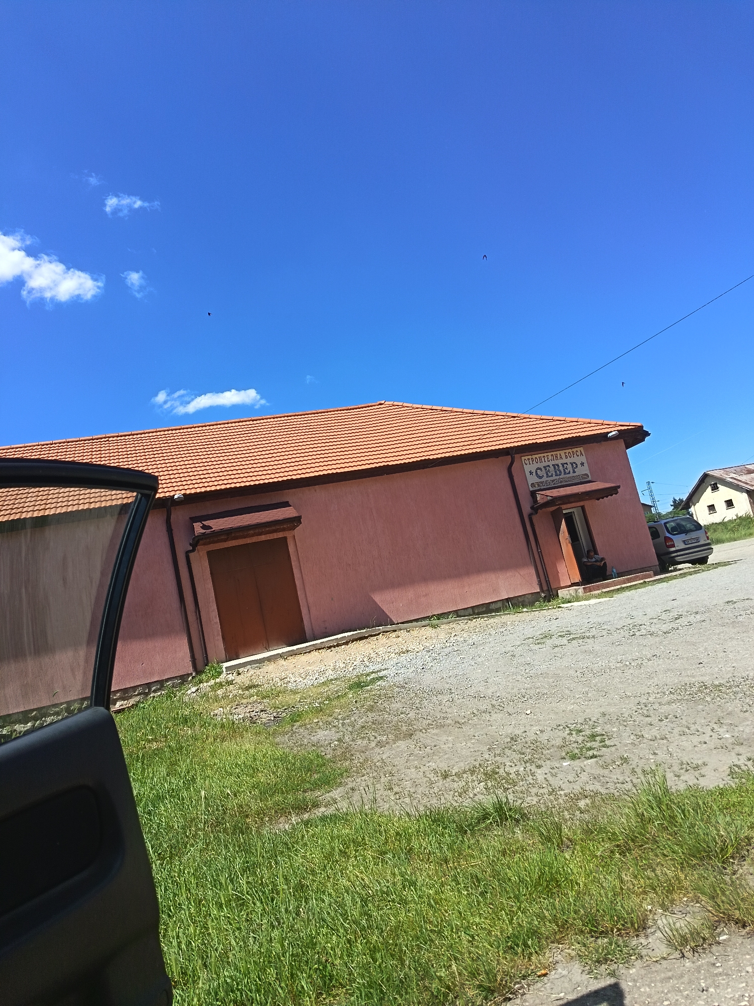 Person relaxes in car near building in Drenovets