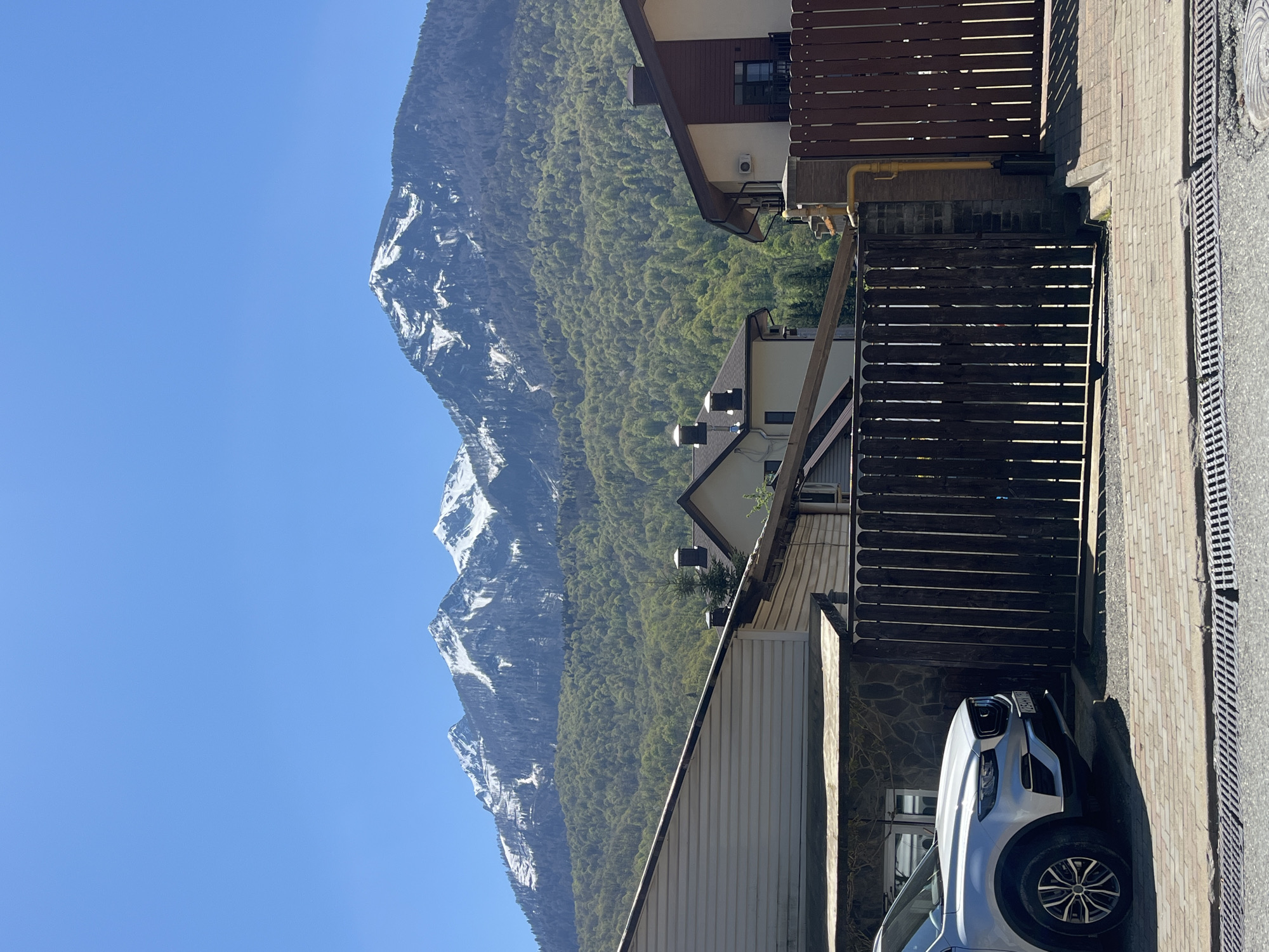 Morning street scene captured in mountain-backdrop city neighborhood