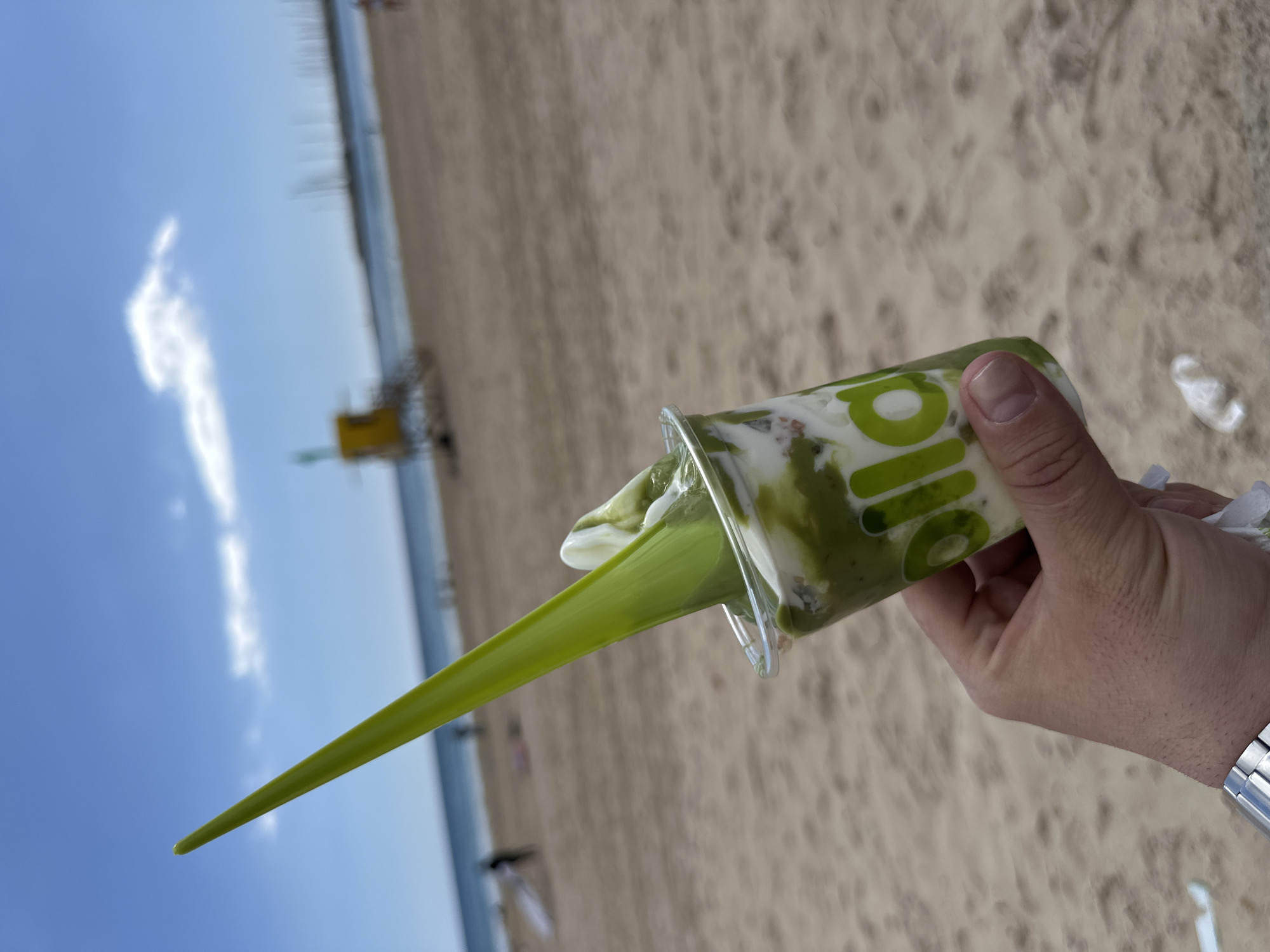 Beachgoer enjoys green smoothie drink in Palma de Mallorca