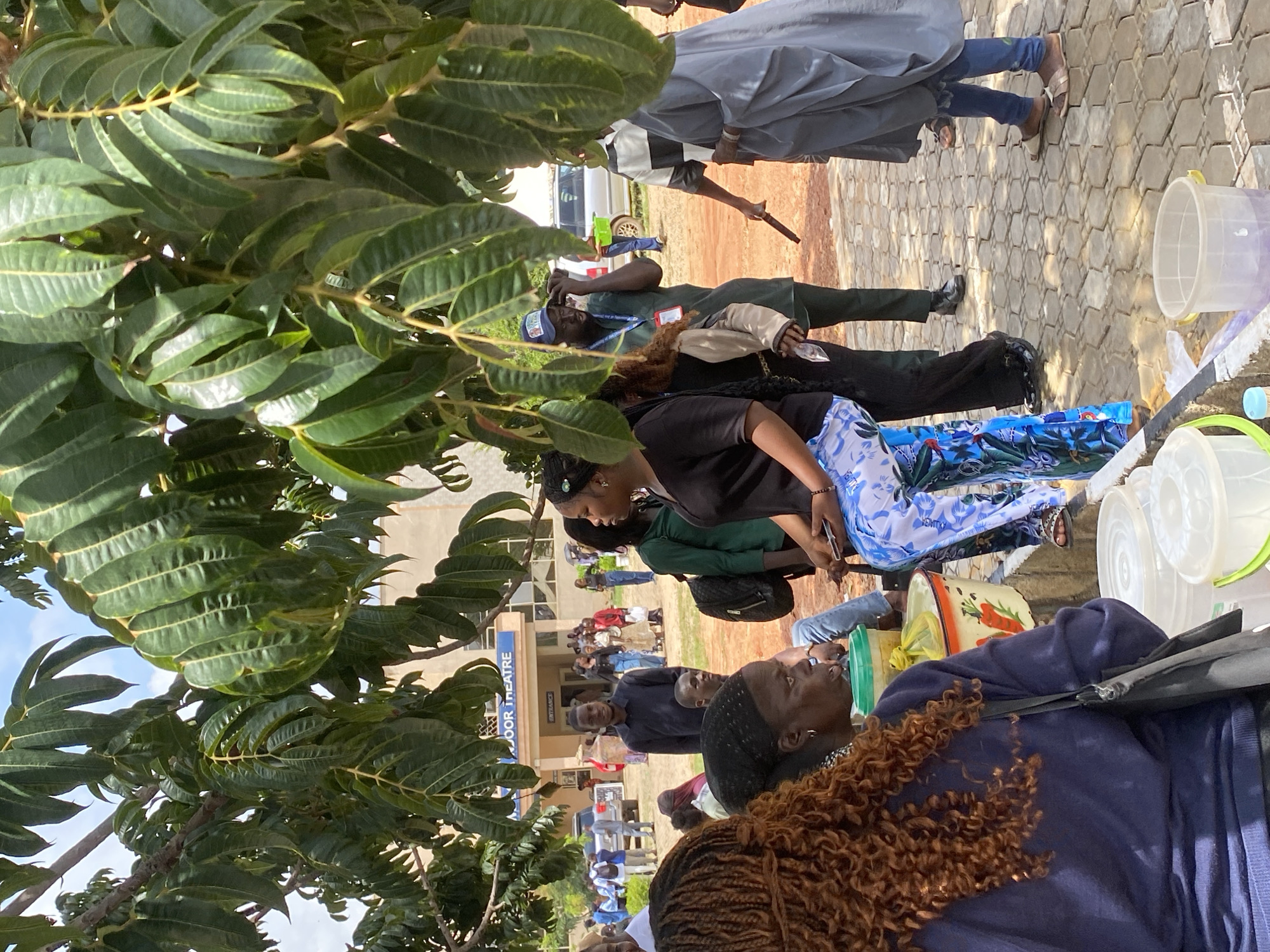 Campus pop-up event in Jos with vendors, auto-rickshaws, and crowds