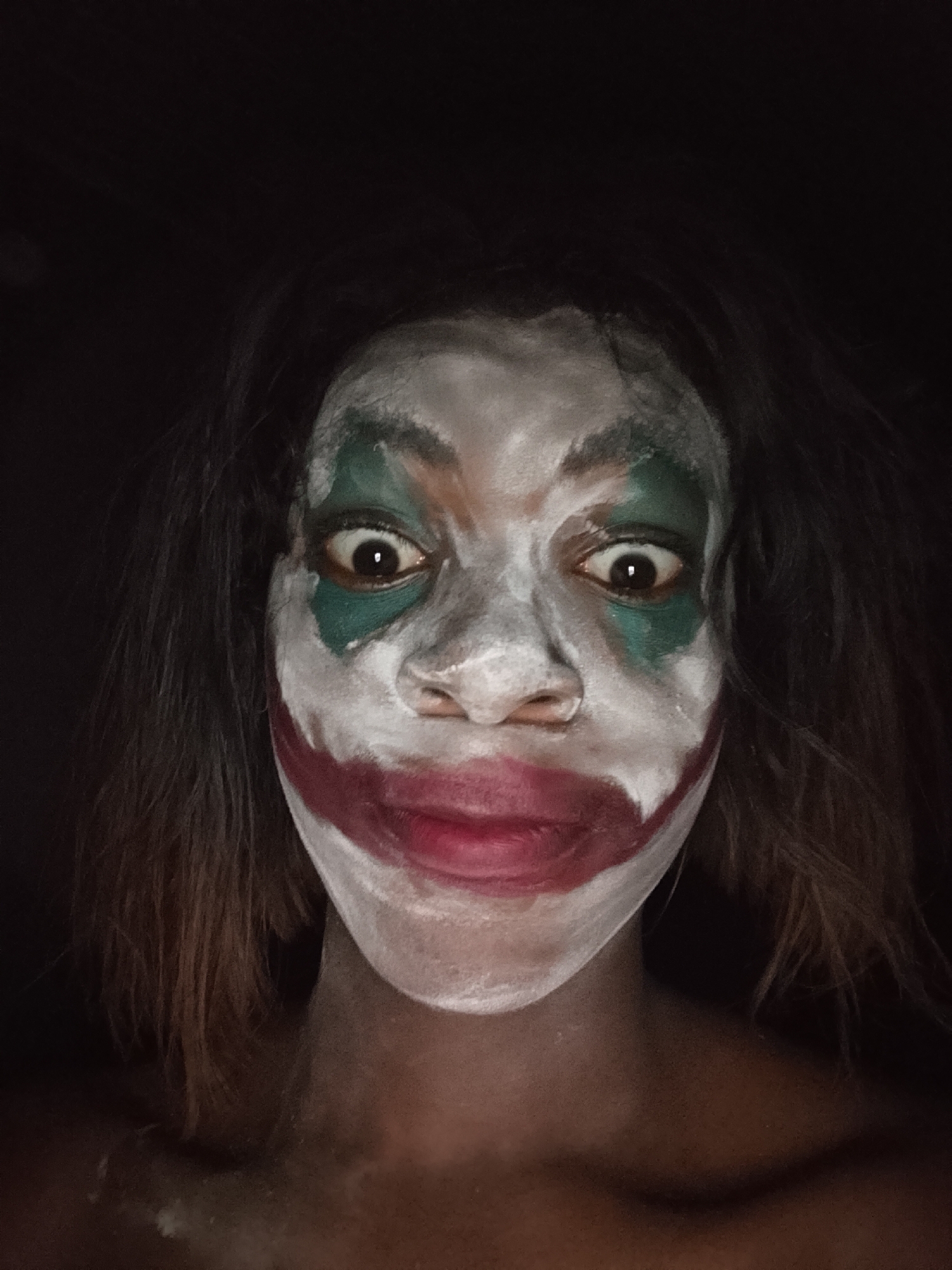 Person photographed in Joker theatrical makeup during evening hours