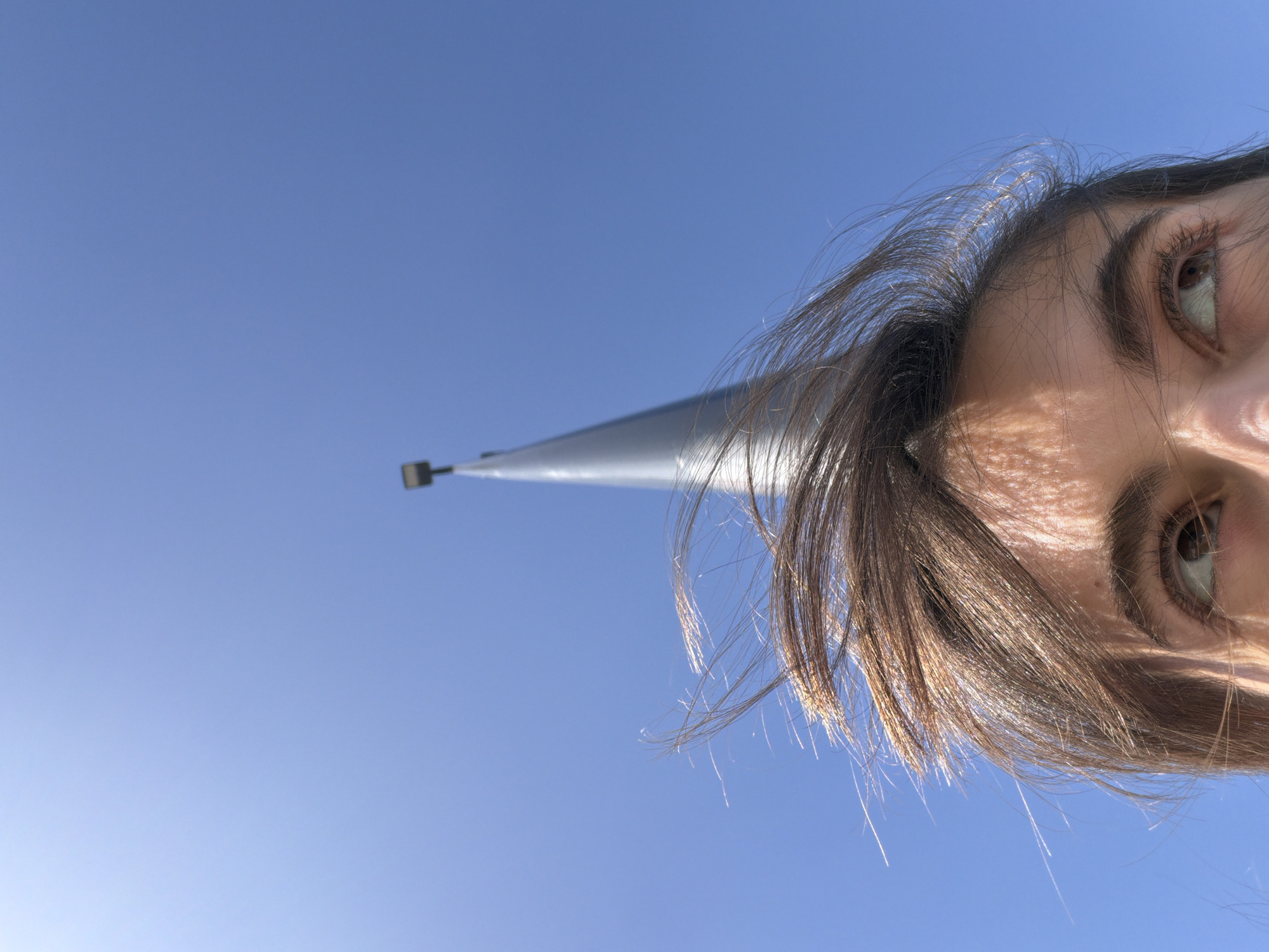 Person photographed from below against clear sky in Mascouche