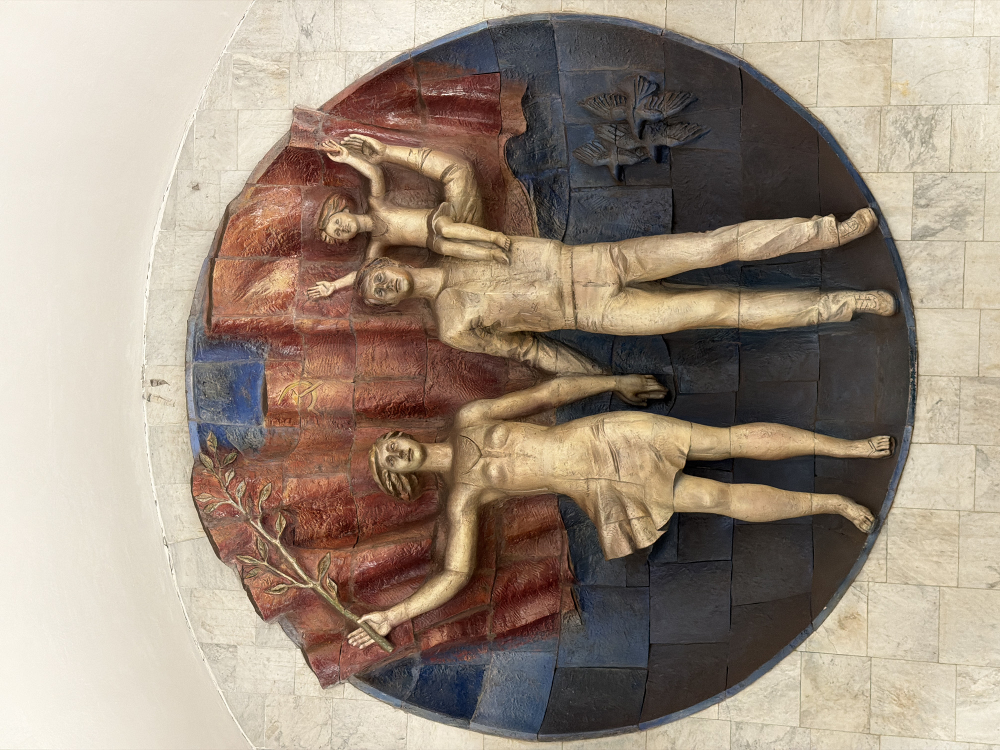Soviet-style bas-relief sculpture of family, flag, and birds in Moscow