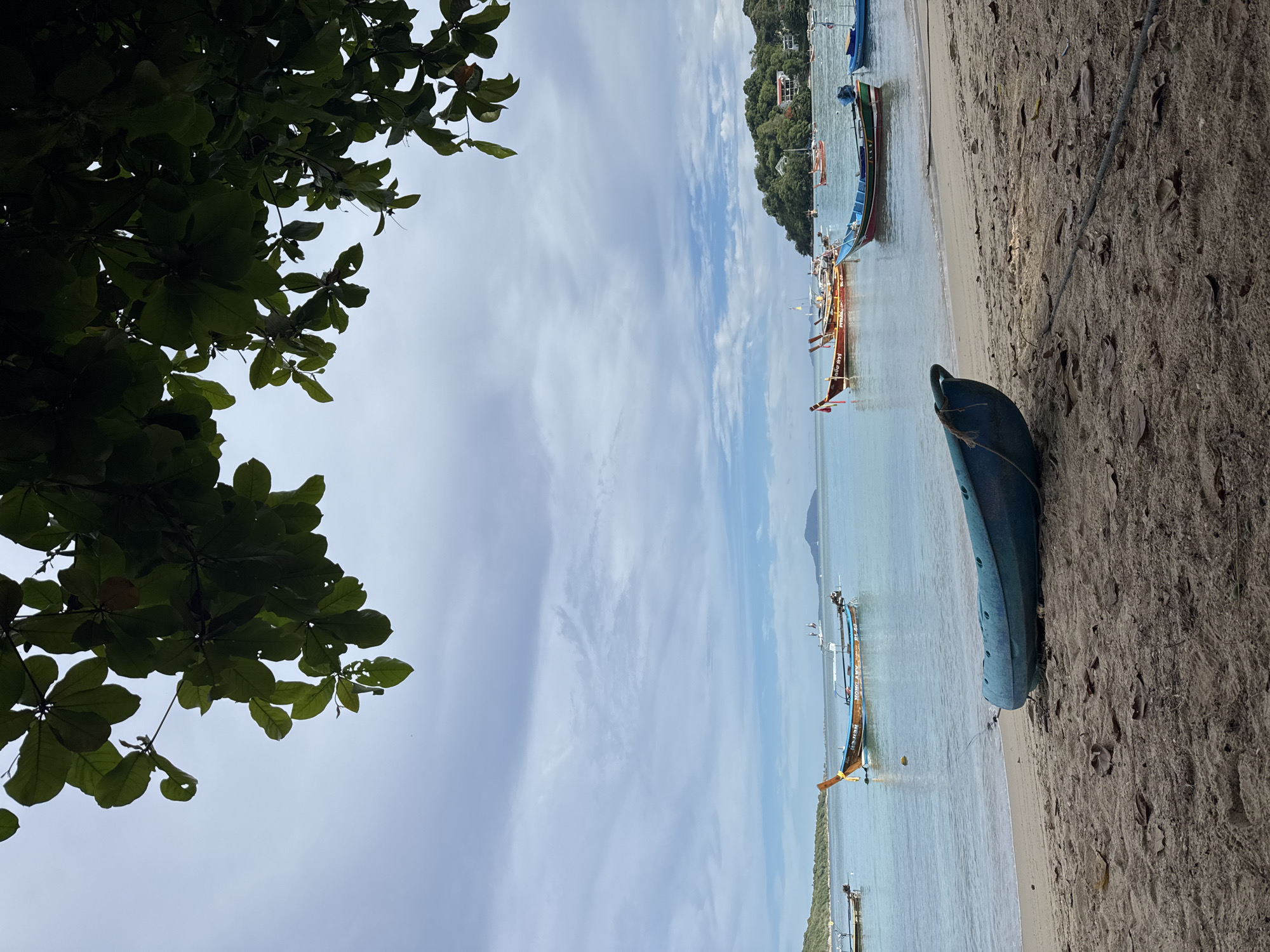 Kayaks on Rawai beach, green mangoes at a nearby stand