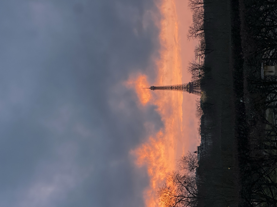 Dramatic sunset illuminates Eiffel Tower amid stormy Paris skies