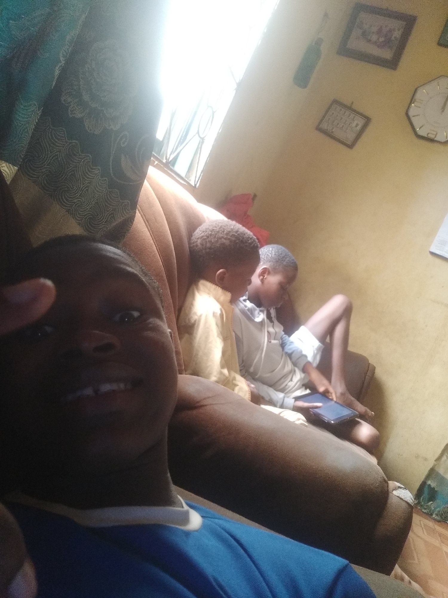 Boys capture selfies and use tablet during casual home gathering